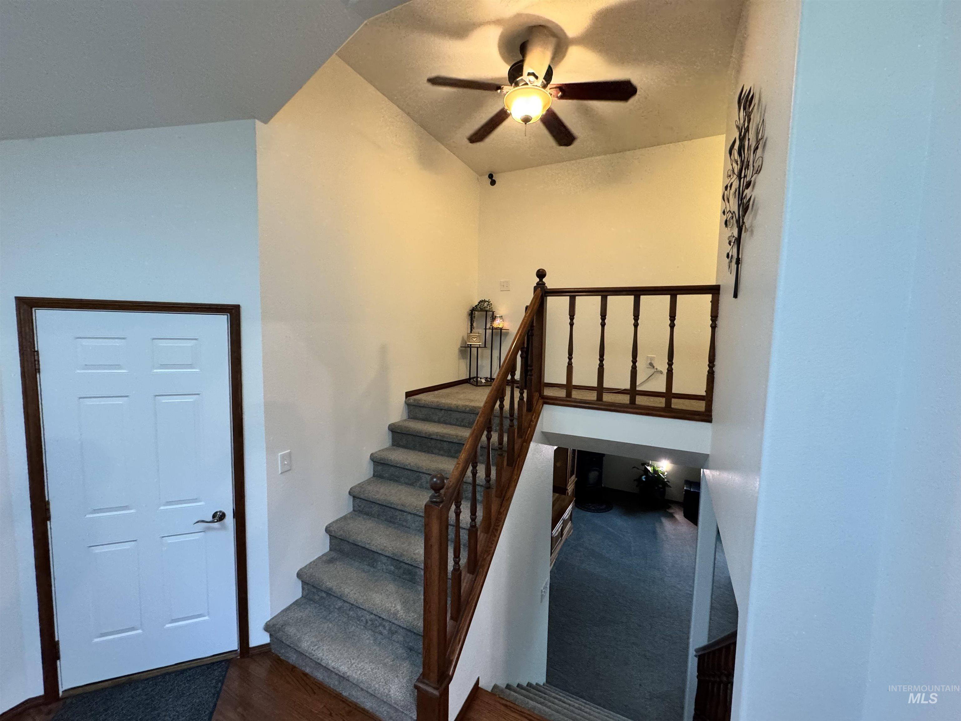 Stairway featuring ceiling fan and wood finished floors