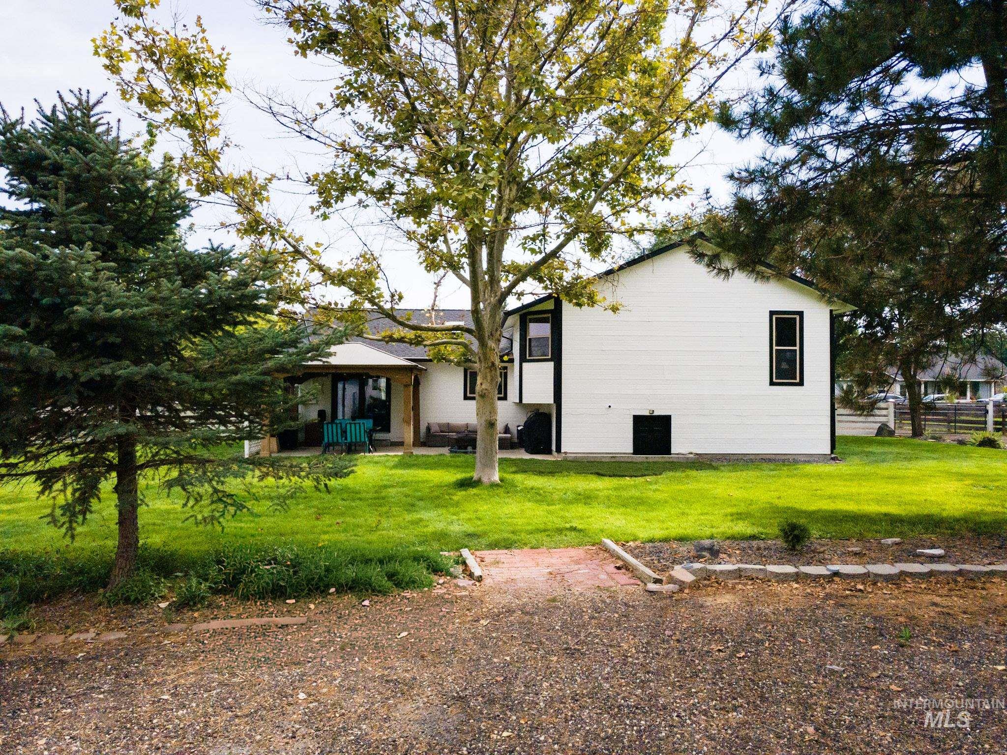 Back of house with a yard and a patio