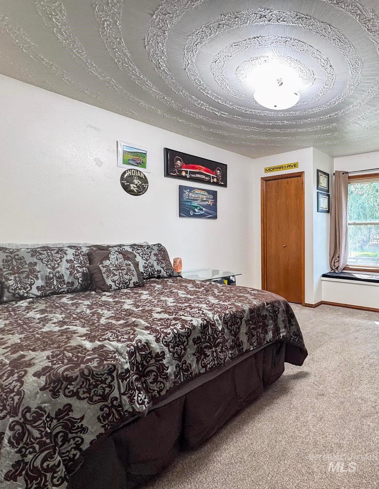 Bedroom featuring light colored carpet, an office area, and two closets
