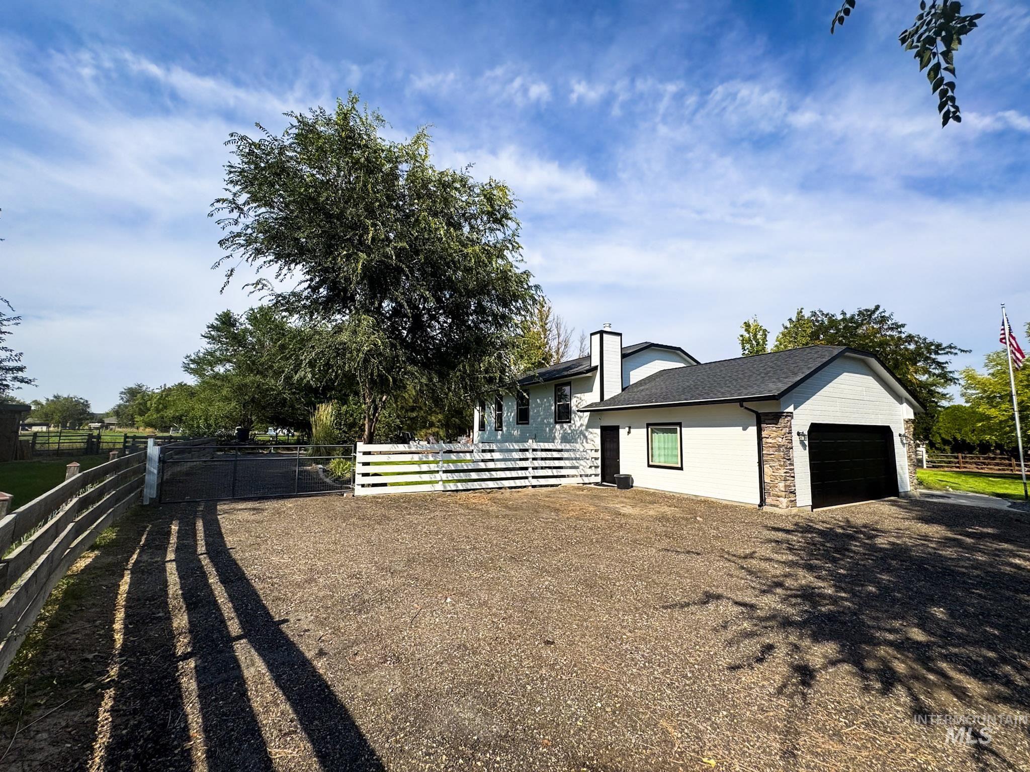 View of property exterior featuring stone siding, a garage, and driveway