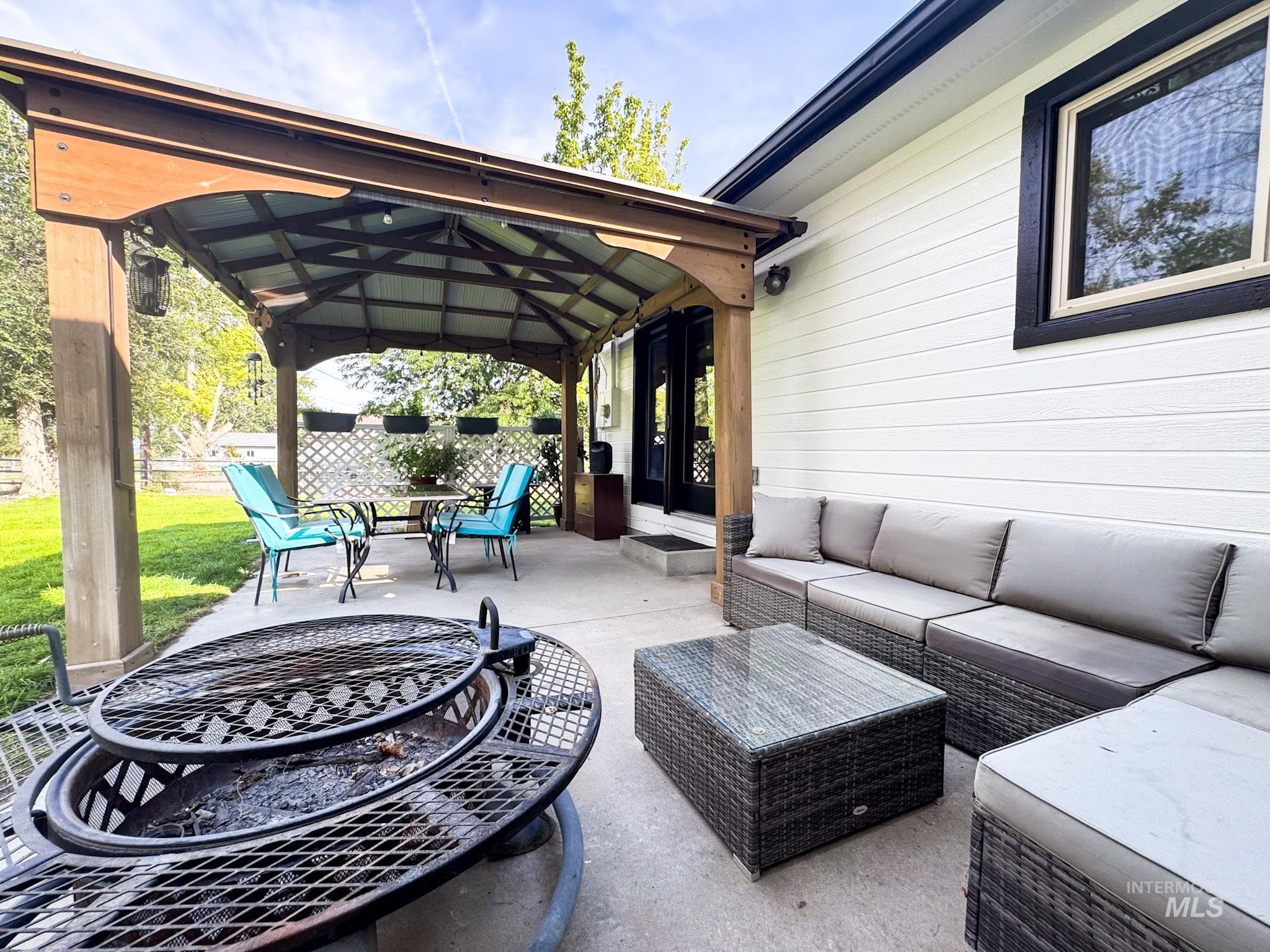 View of patio featuring a gazebo and an outdoor living space with a fire pit