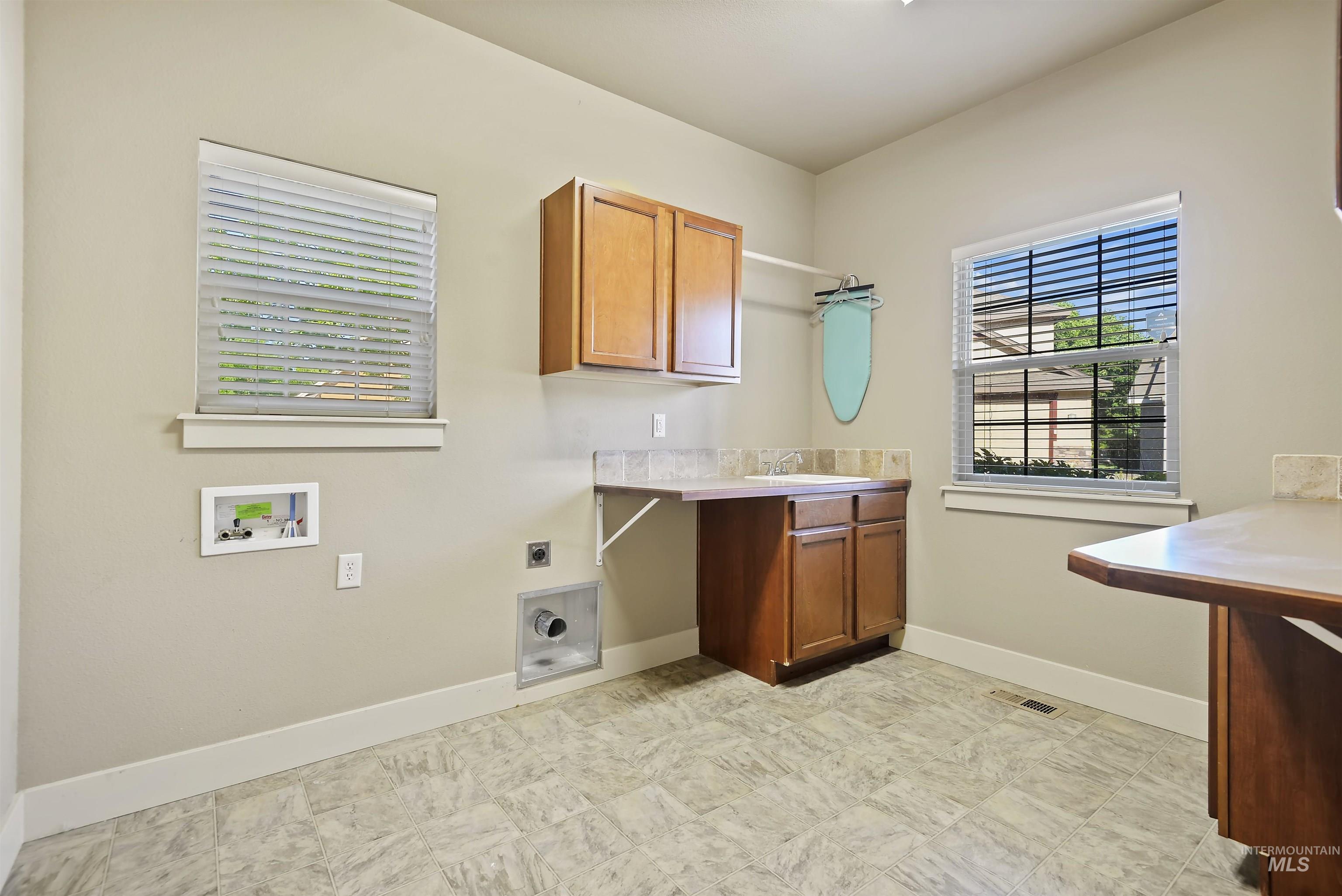 Washroom featuring electric dryer hookup, cabinet space, and hookup for a washing machine