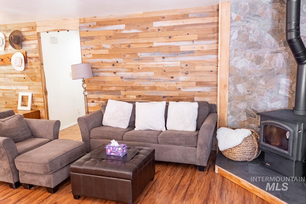 Living room with a wood stove, wood finished floors, and wood walls