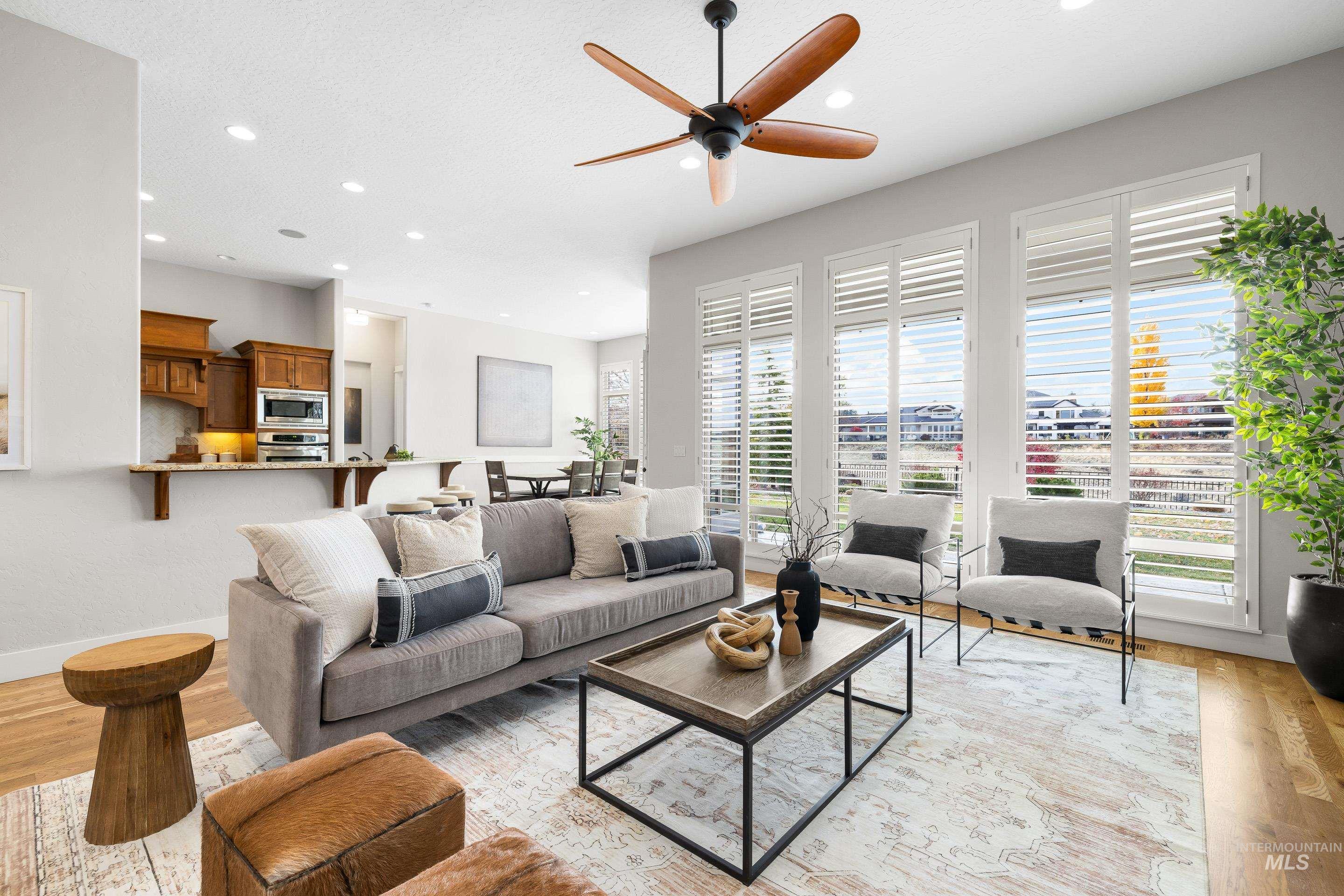Living room featuring light wood-type flooring, a ceiling fan, and recessed lighting