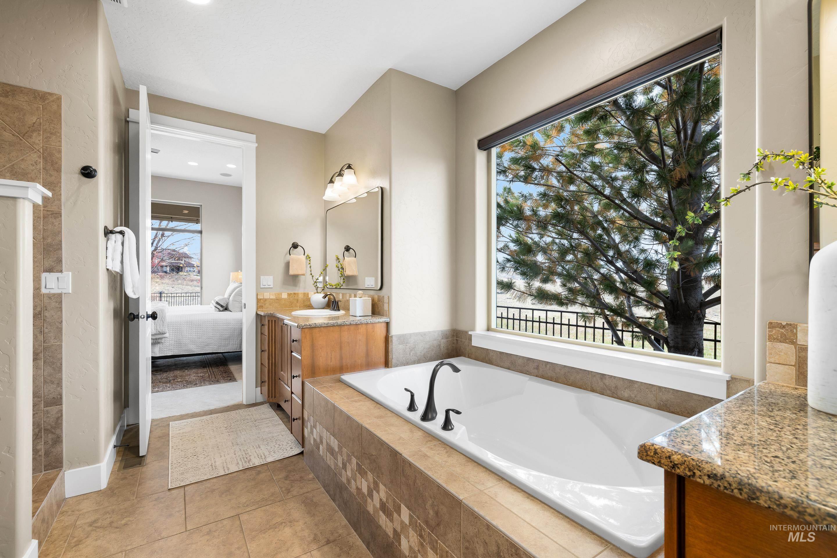 Ensuite bathroom with vanity, a garden tub, light tile patterned floors, a tile shower, and recessed lighting