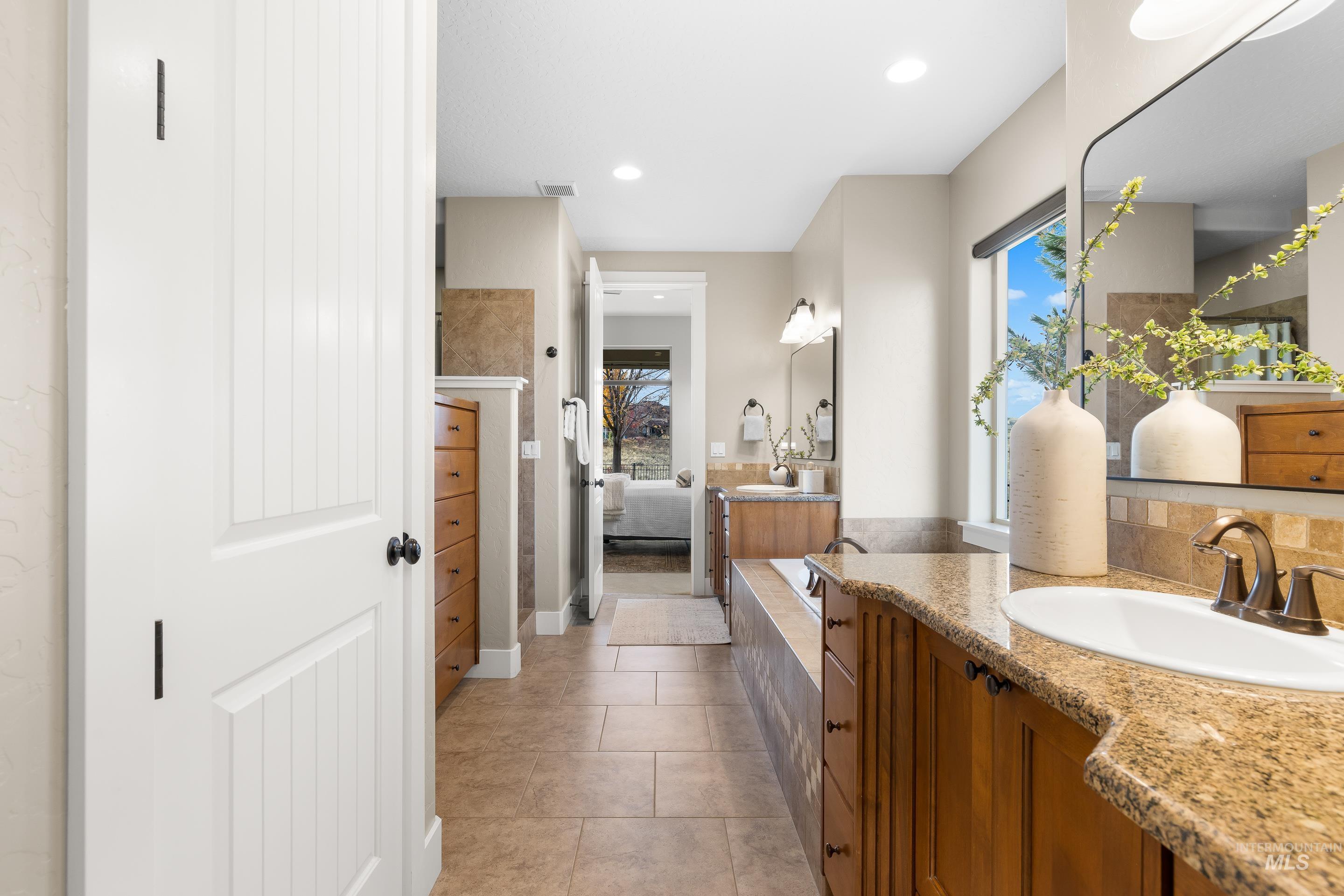 Bathroom with two vanities, light tile patterned floors, ensuite bathroom, and recessed lighting