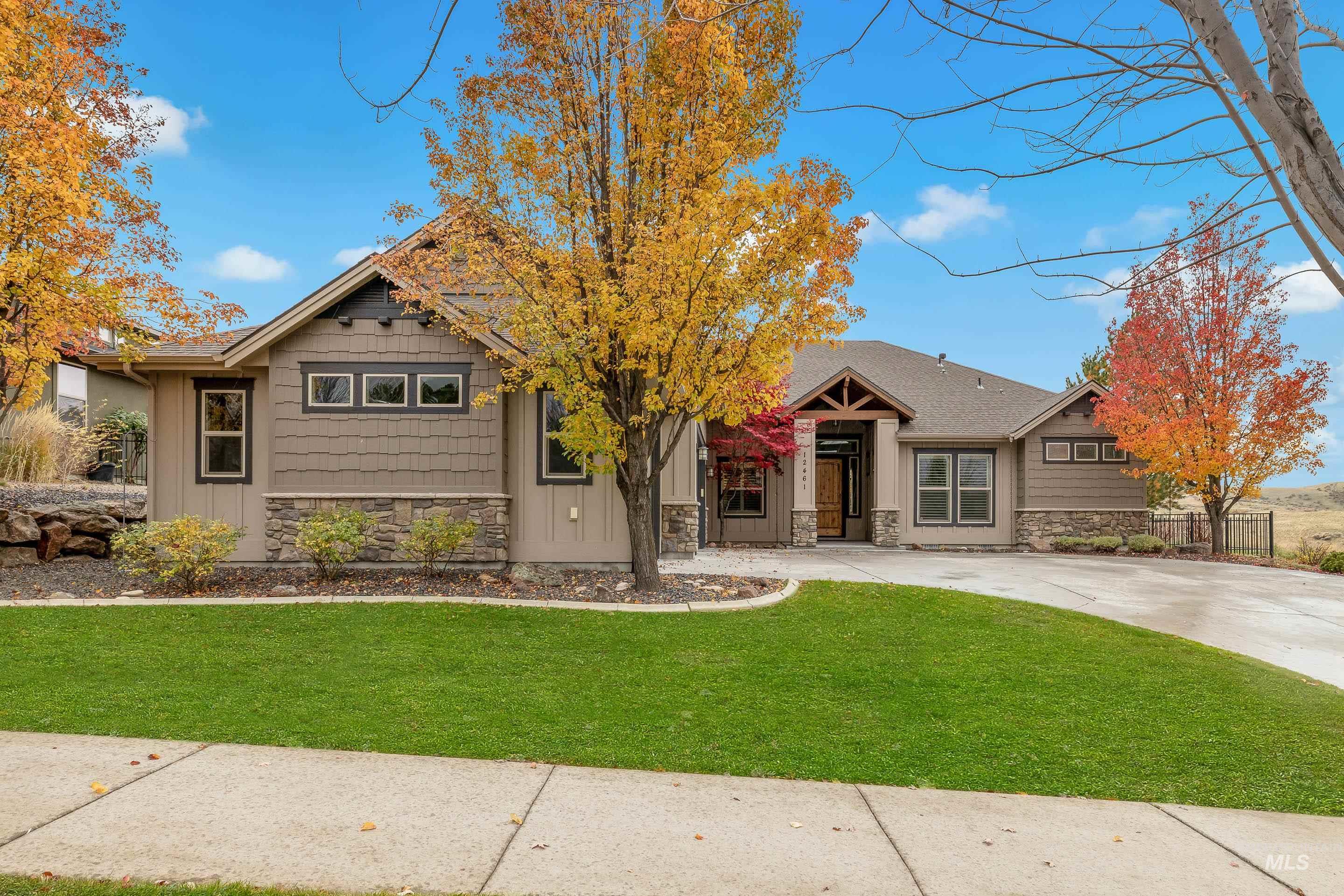 Craftsman-style home featuring stone siding, a front yard, and board and batten siding
