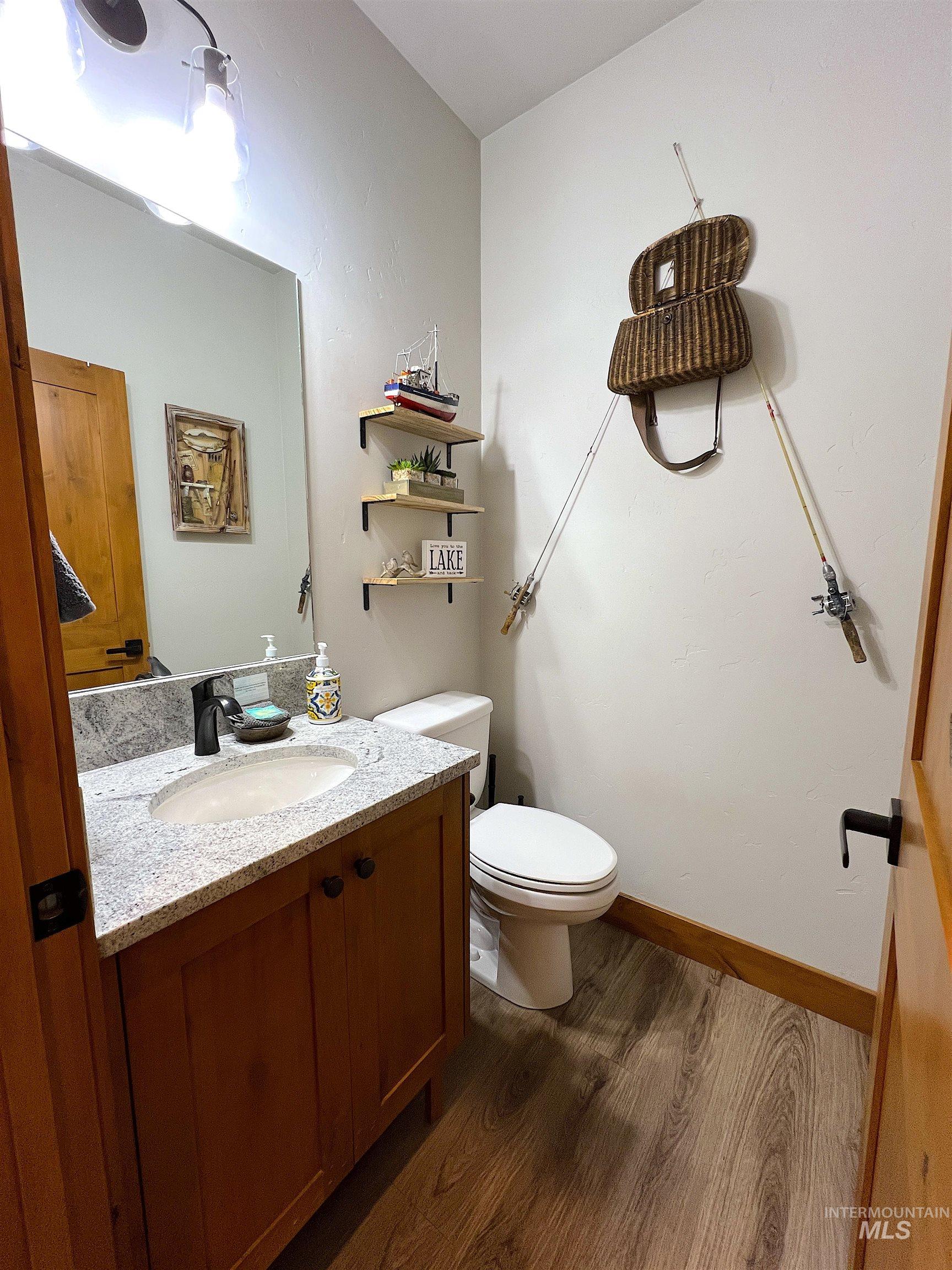 Half bathroom featuring dark wood-type flooring and vanity