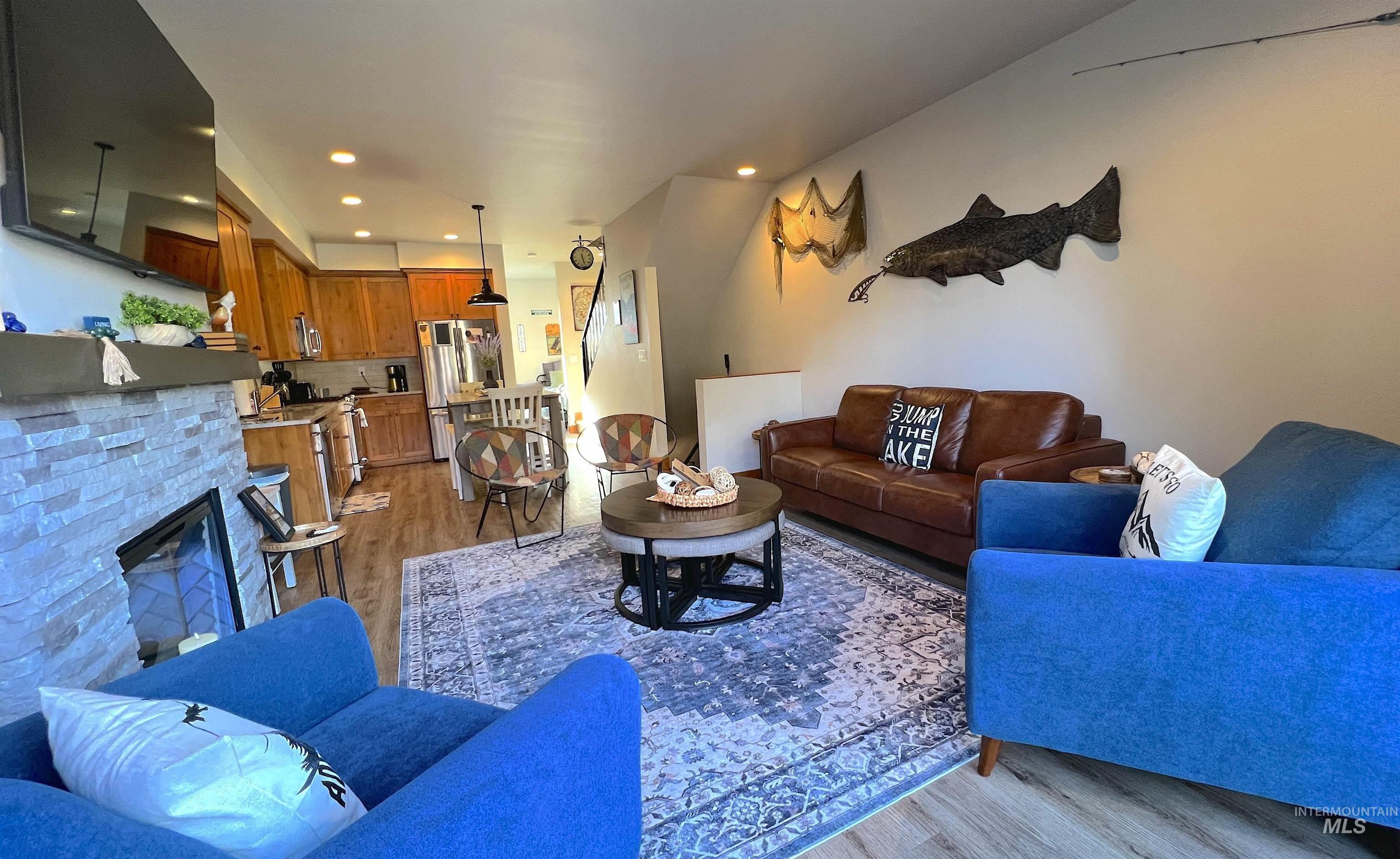 Living area featuring light wood finished floors, a fireplace, and recessed lighting