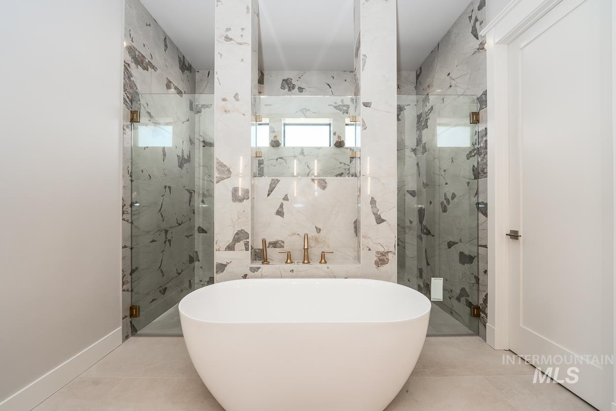 Bathroom featuring a marble finish shower, a soaking tub, and tile patterned flooring
