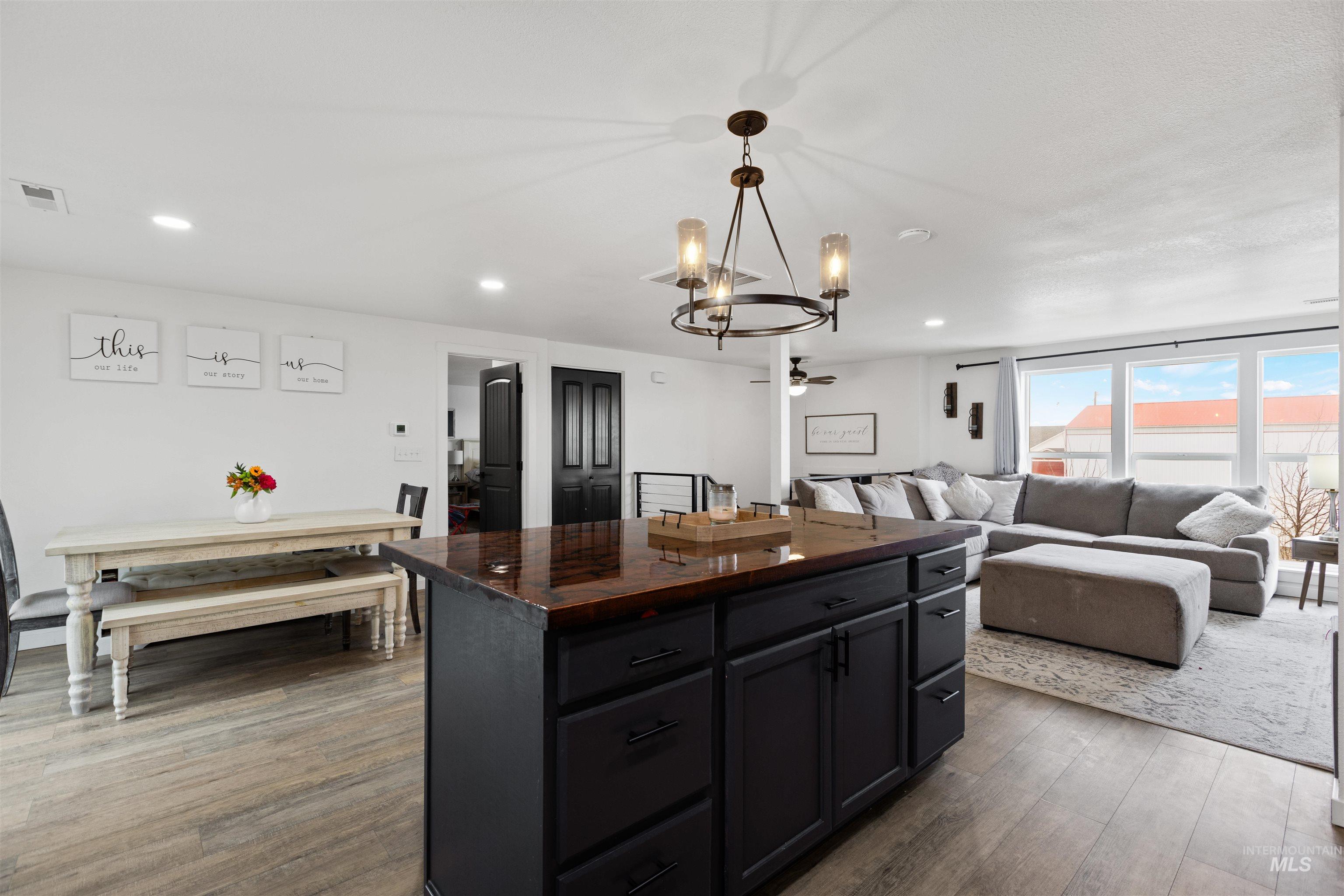Kitchen featuring a center island, butcher block countertops, dark wood-type flooring, a chandelier, and open floor plan