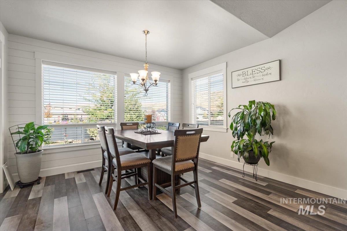 Dining area featuring dark wood-type flooring and a chandelier