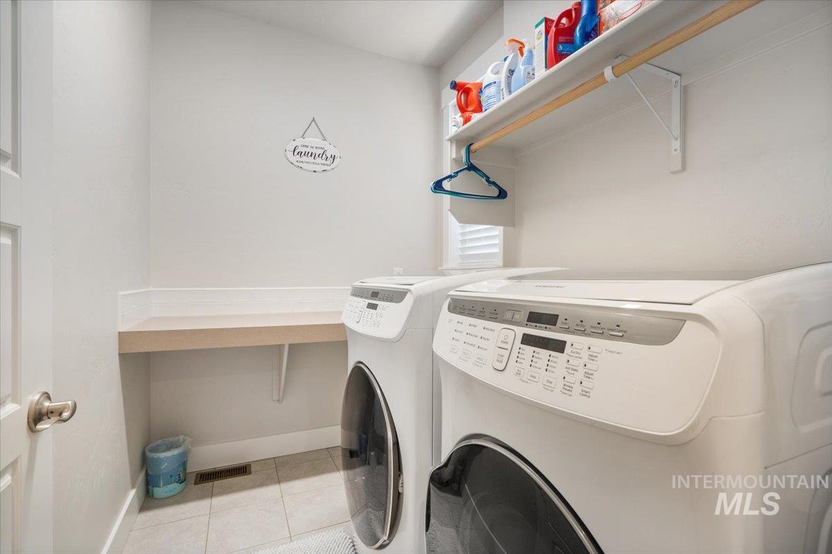 Laundry area featuring light tile patterned flooring and separate washer and dryer