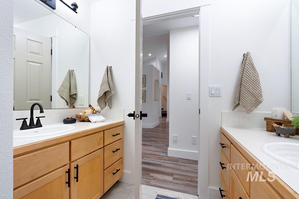 Full bathroom featuring two vanities and light wood-style flooring