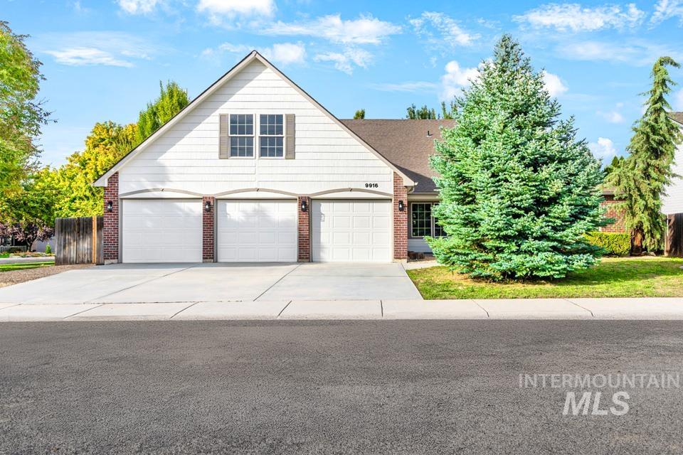 Traditional home with driveway and brick siding