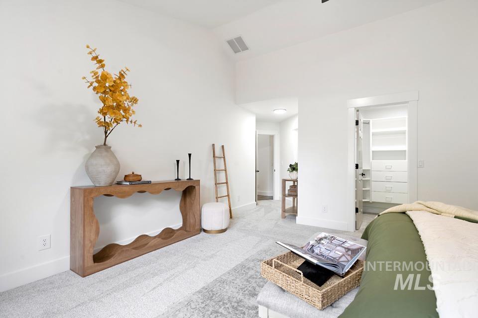 Bedroom featuring a spacious closet, carpet flooring, and high vaulted ceiling