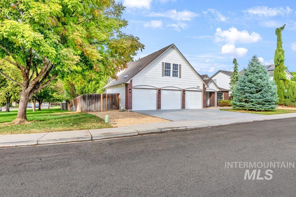 Traditional home with driveway and brick siding