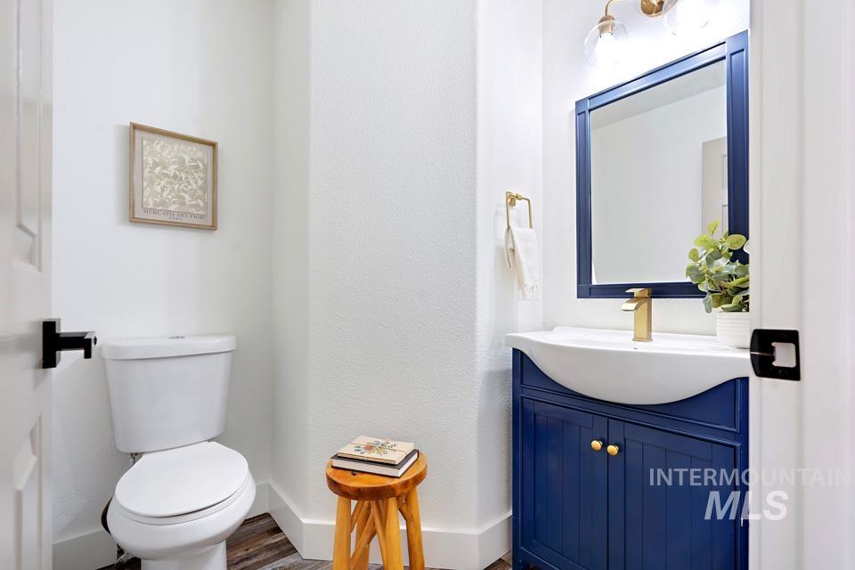 Half bath with vanity and wood finished floors