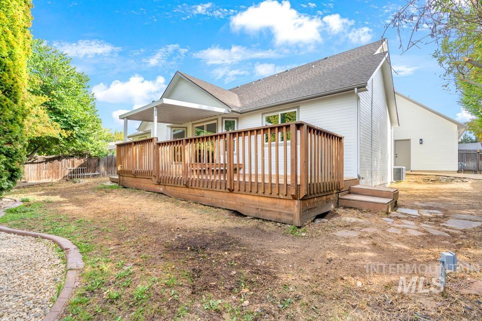 Rear view of property featuring a wooden deck and a shingled roof