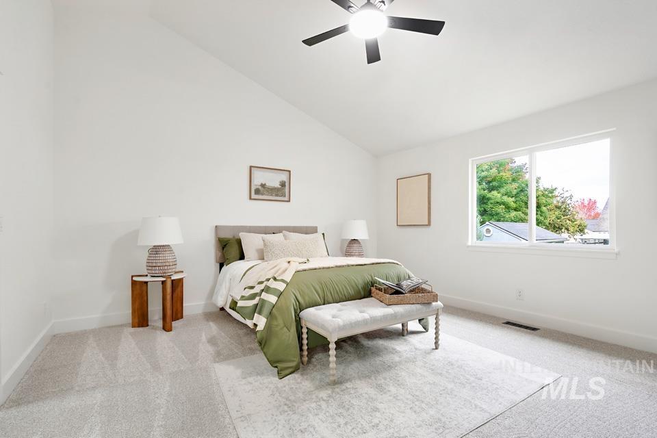 Bedroom with carpet, a ceiling fan, and high vaulted ceiling