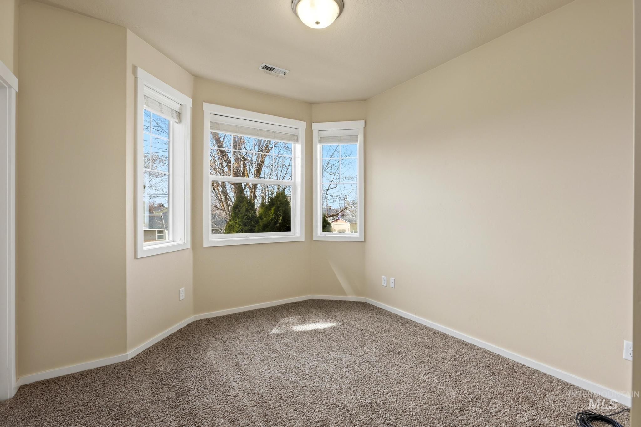 Carpeted empty room with baseboards