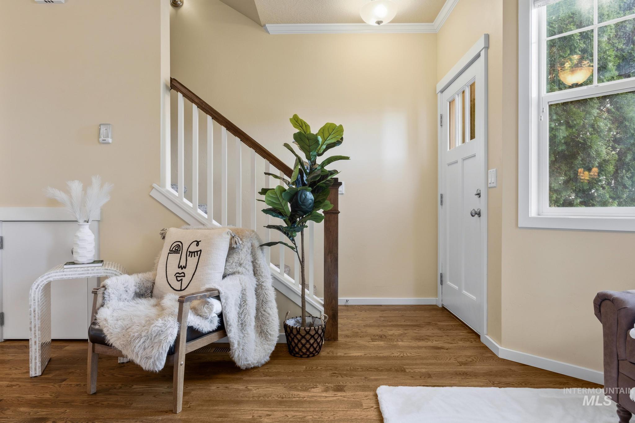 Entryway featuring wood finished floors and ornamental molding