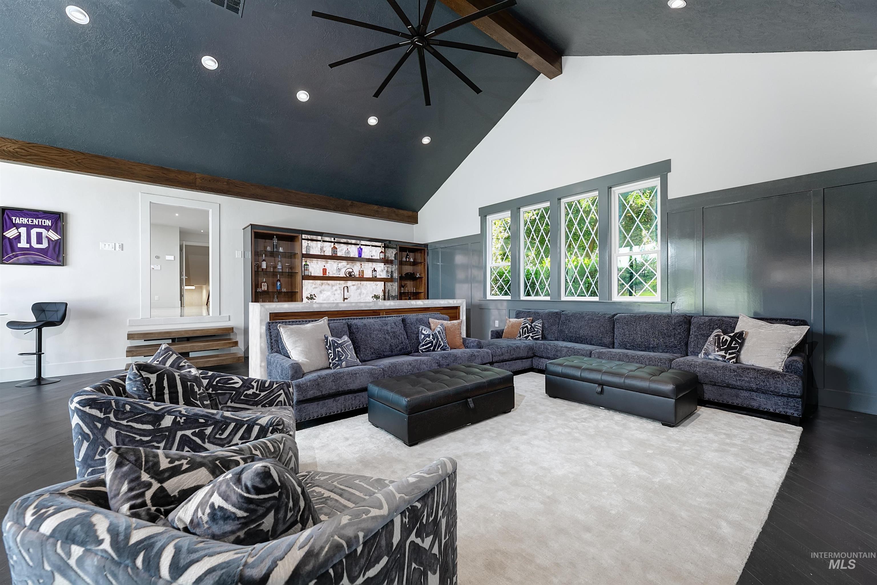 Great room with wine bar, dark wood finished floors, recessed lighting, high vaulted ceiling, and beam ceiling.