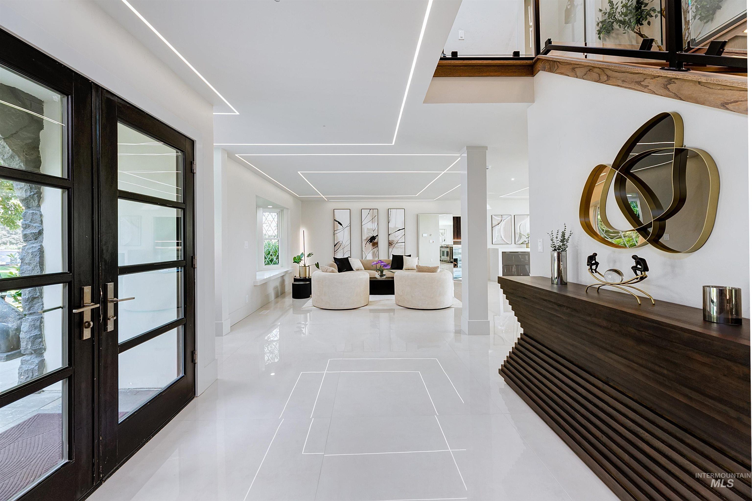 Entrance foyer with french doors and light tile patterned flooring and pin lighting.