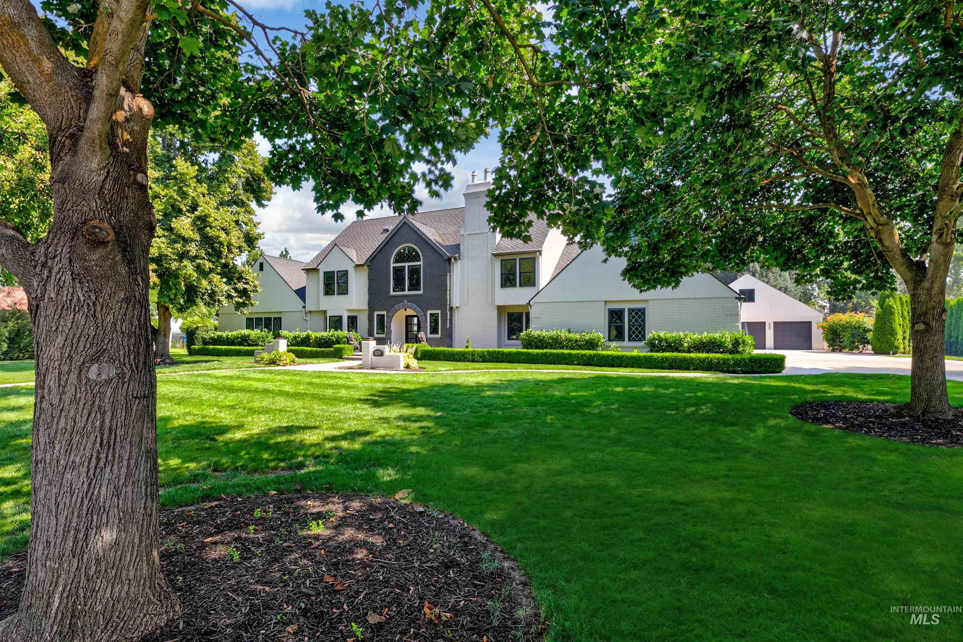 View of front facade with a front yard, driveway, attached garage, and a detached garage.