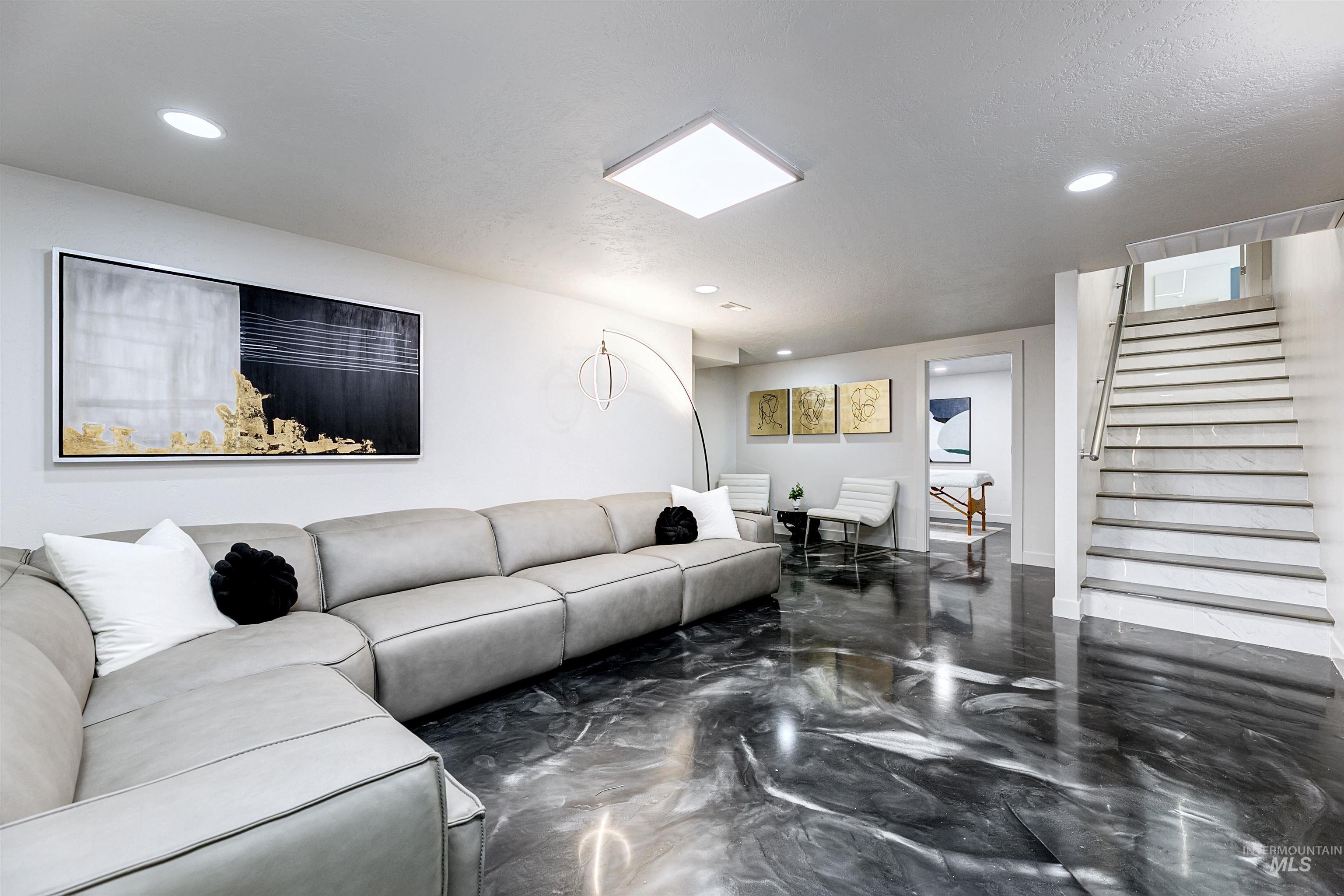 Downstairs living room area featuring stairs and recessed lighting.