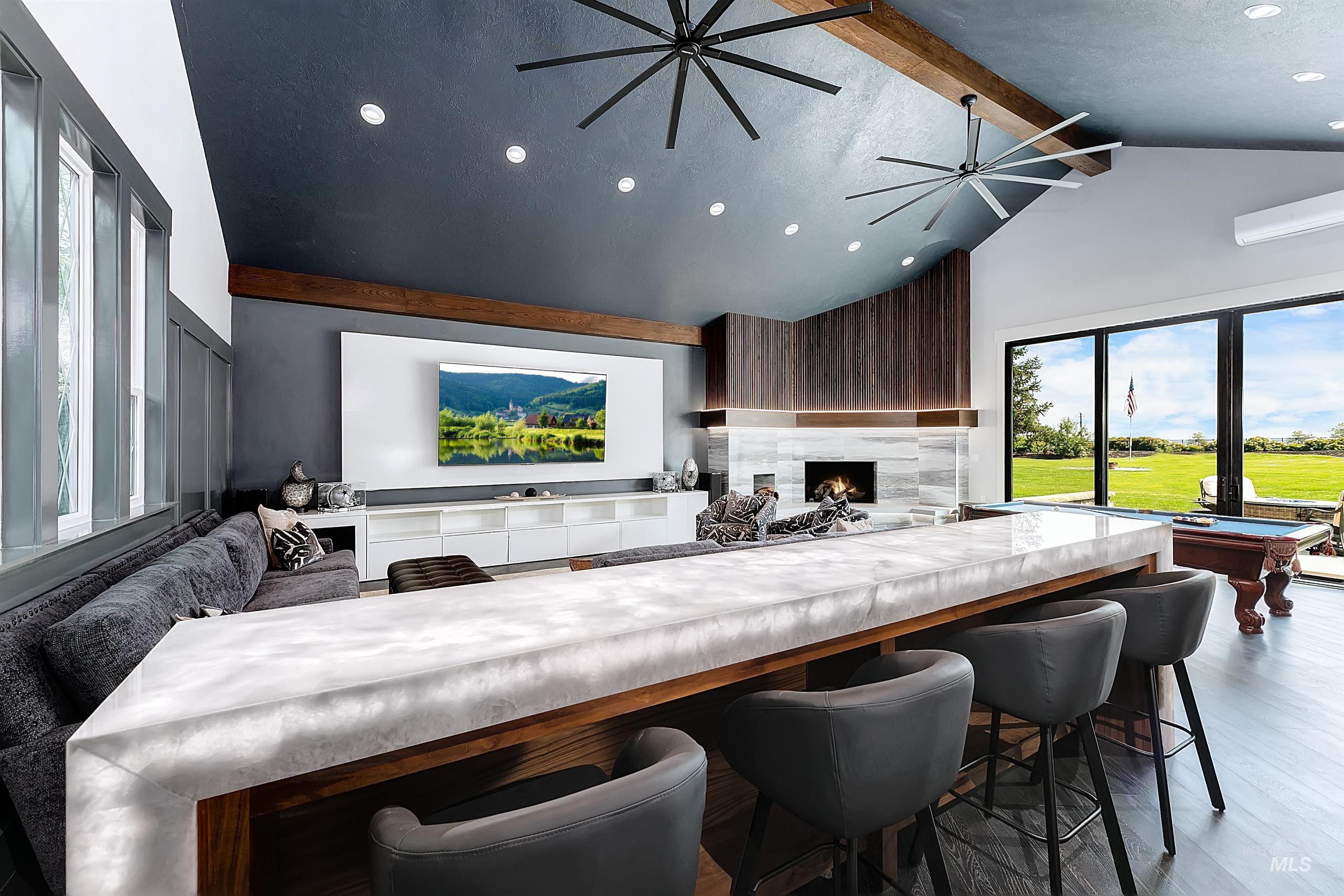 Great room featuring beamed ceiling, a premium fireplace, lit countertops, and recessed lighting.