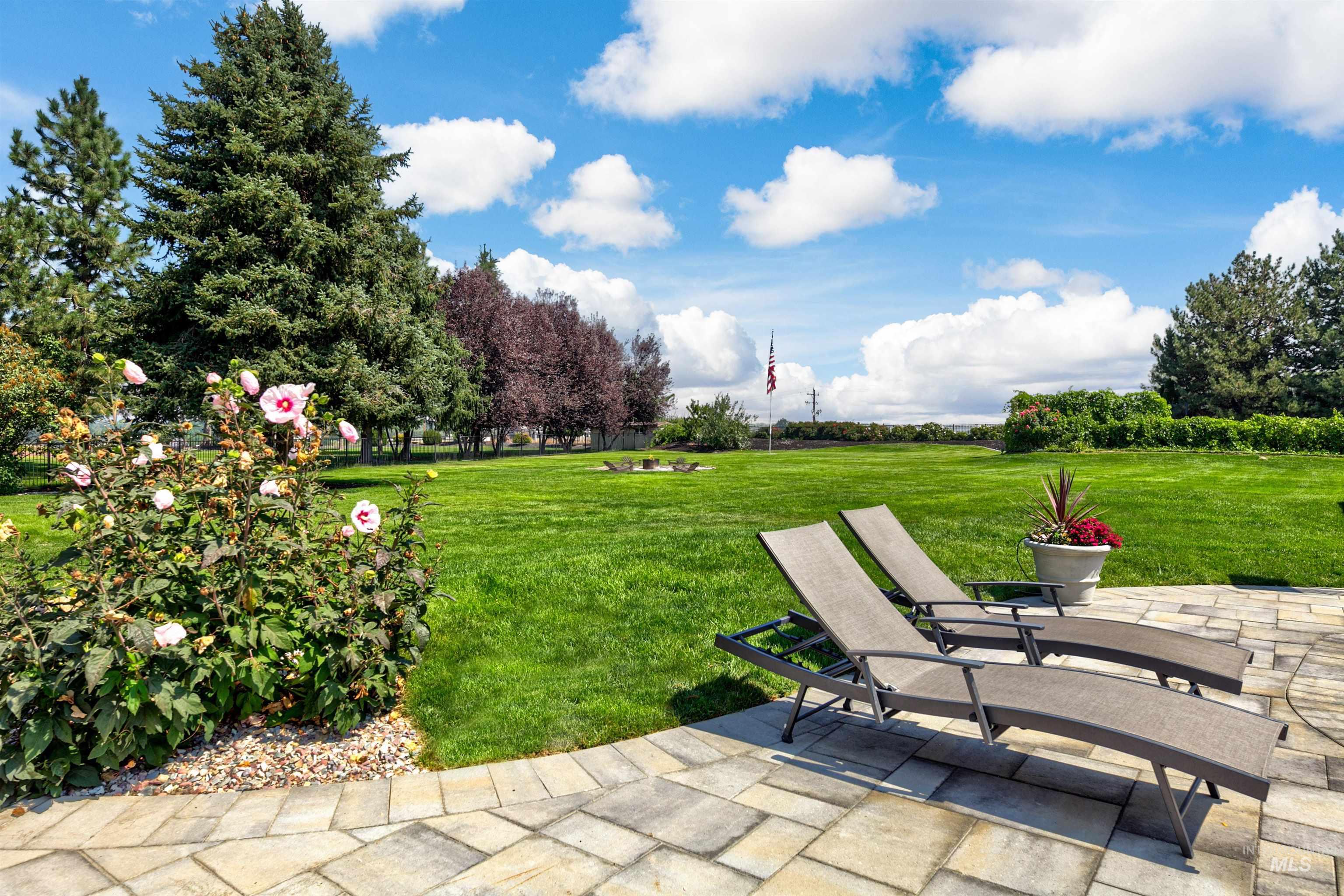 View of sprawling green lawn with and patio area.
