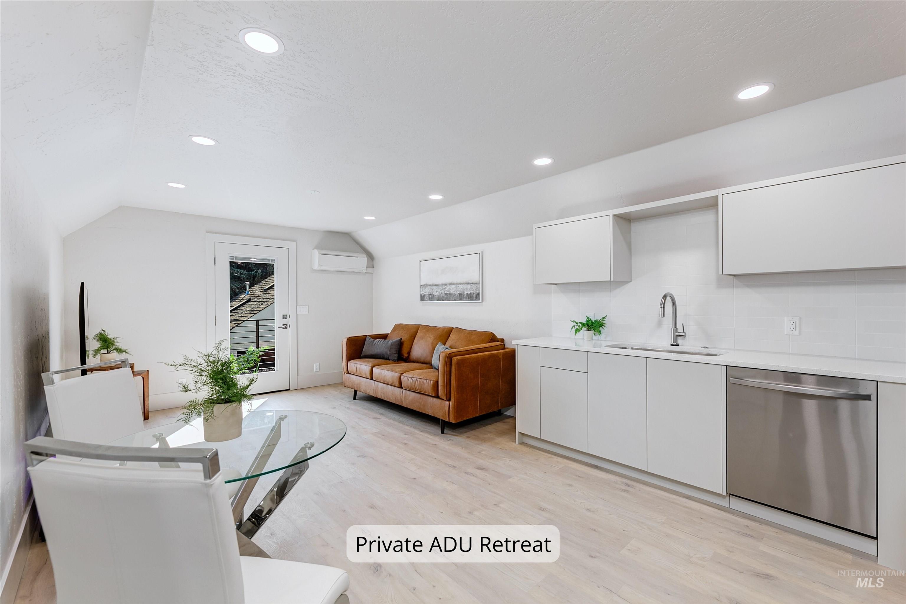 Private ADU living room and dining room area with light wood finished floors, private entrance, and recessed lighting.