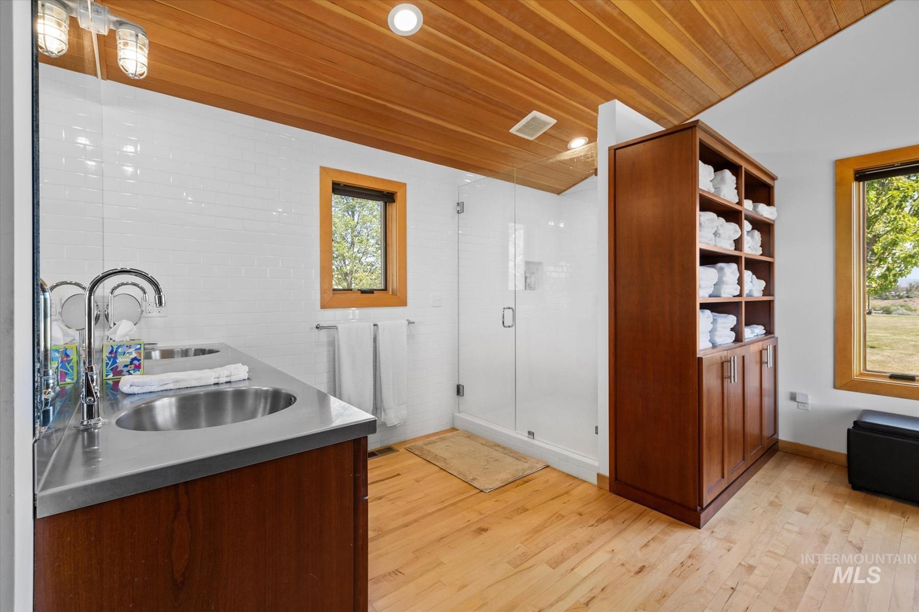 Kitchen with stainless steel counters, wood ceiling, and light wood-style flooring