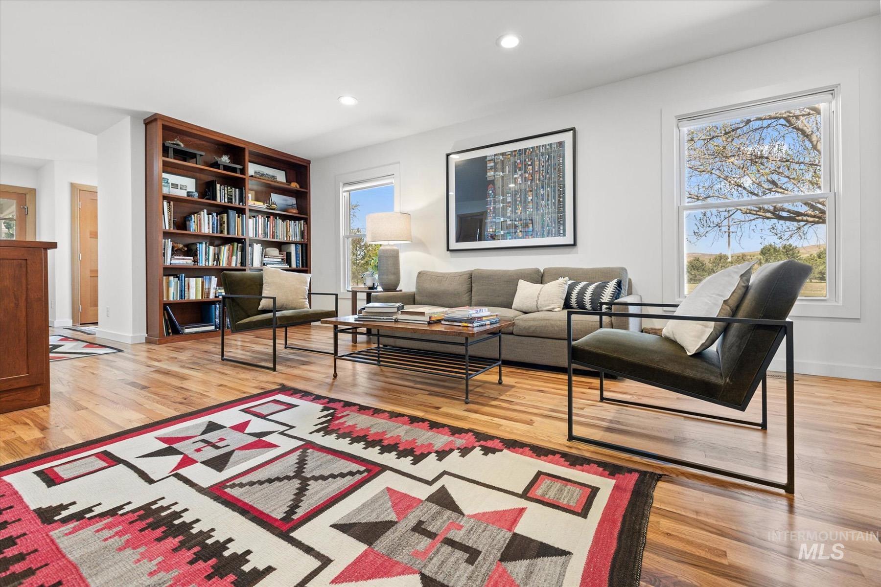 Living area with light wood finished floors and recessed lighting