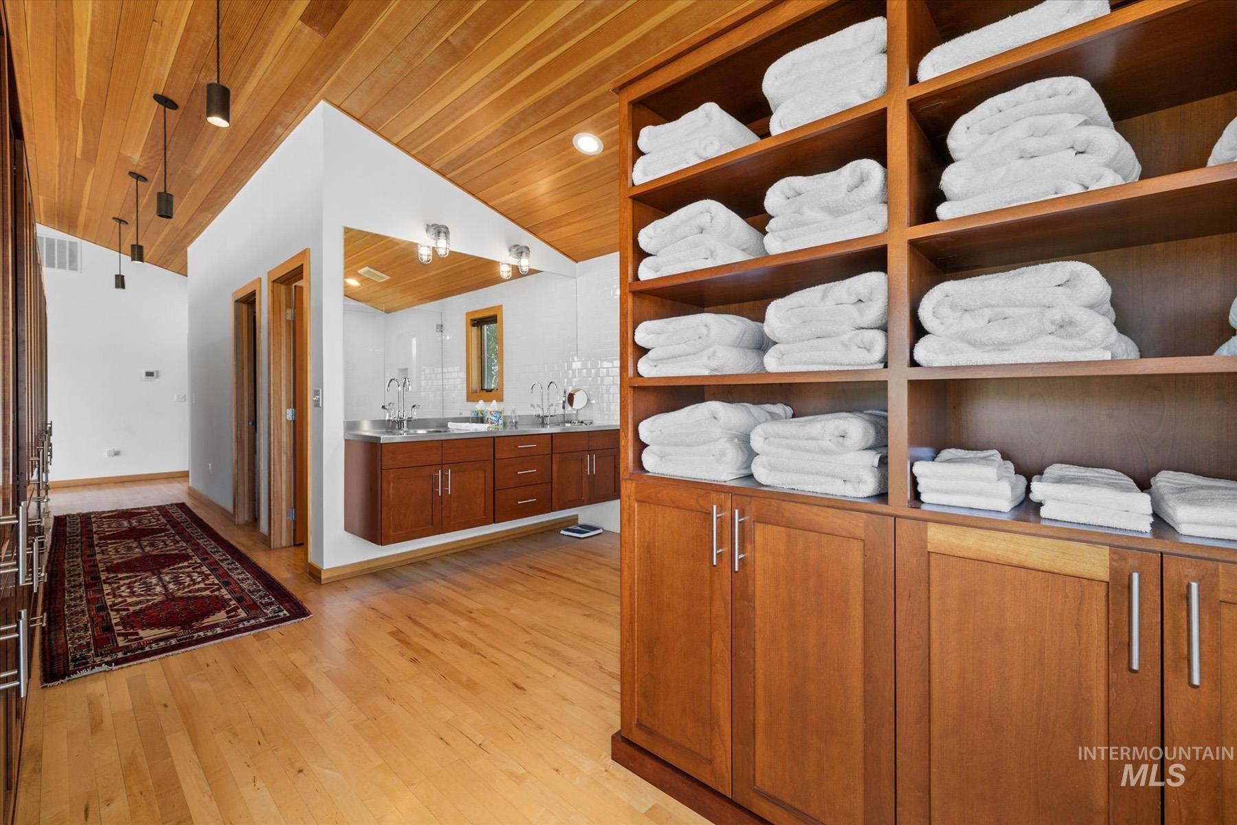 Bathroom featuring wood ceiling, vaulted ceiling, vanity, and wood finished floors