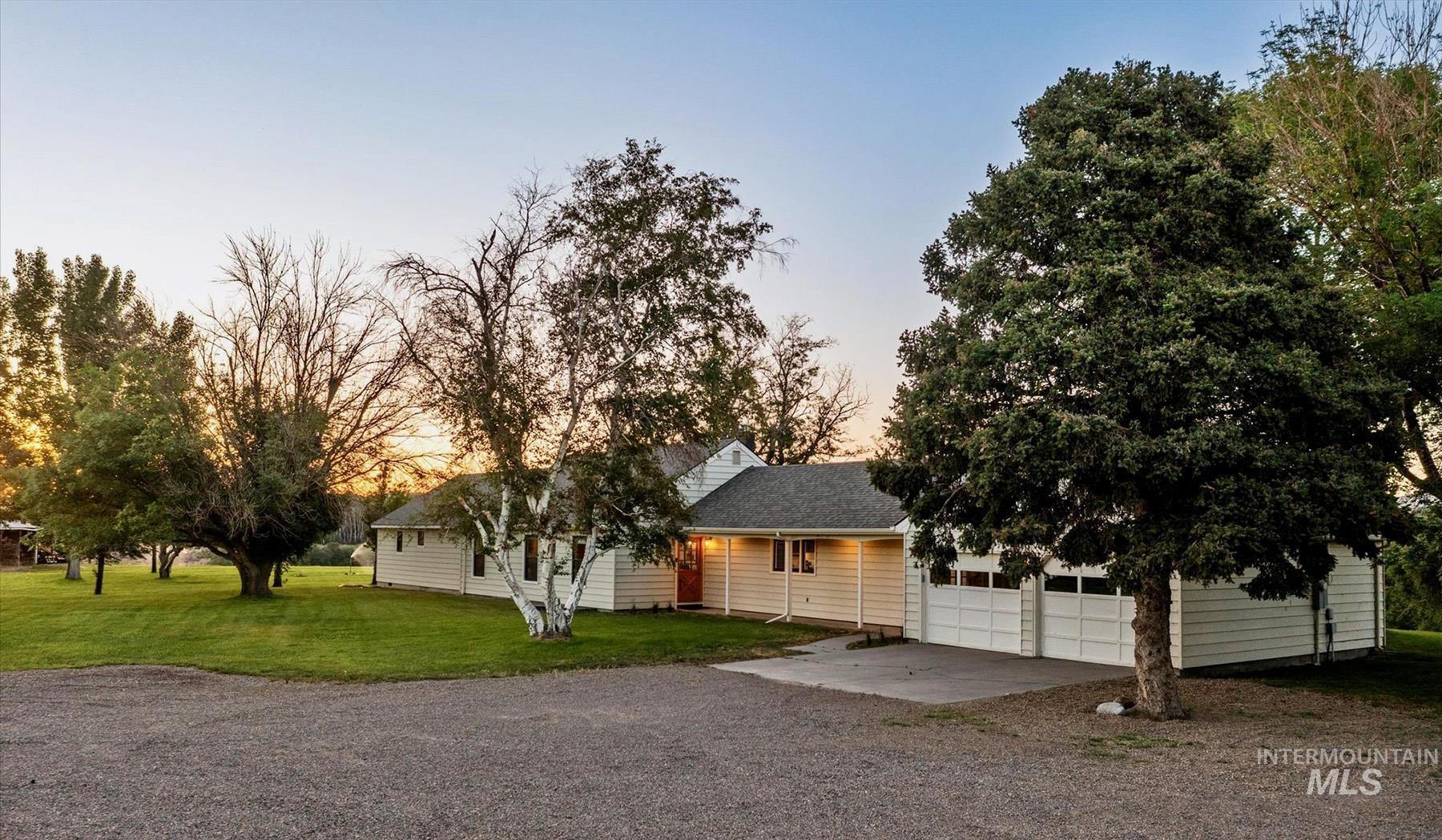 View of front facade with gravel driveway and a front yard