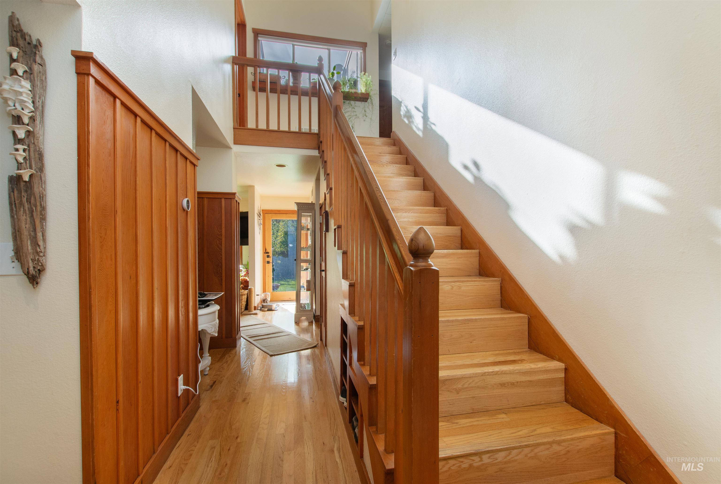 Stairway with a high ceiling and wood finished floors