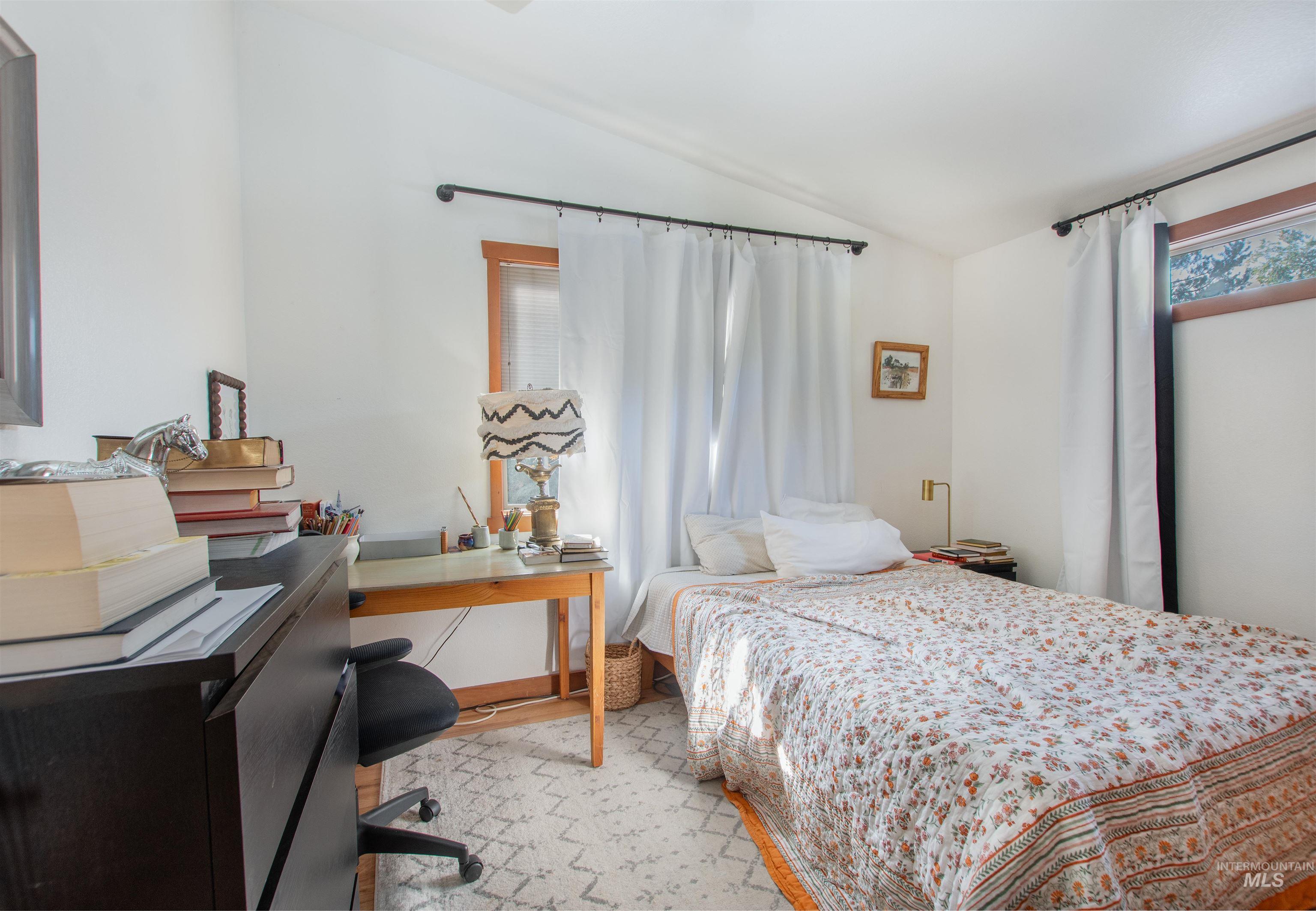 Bedroom featuring lofted ceiling and an office area