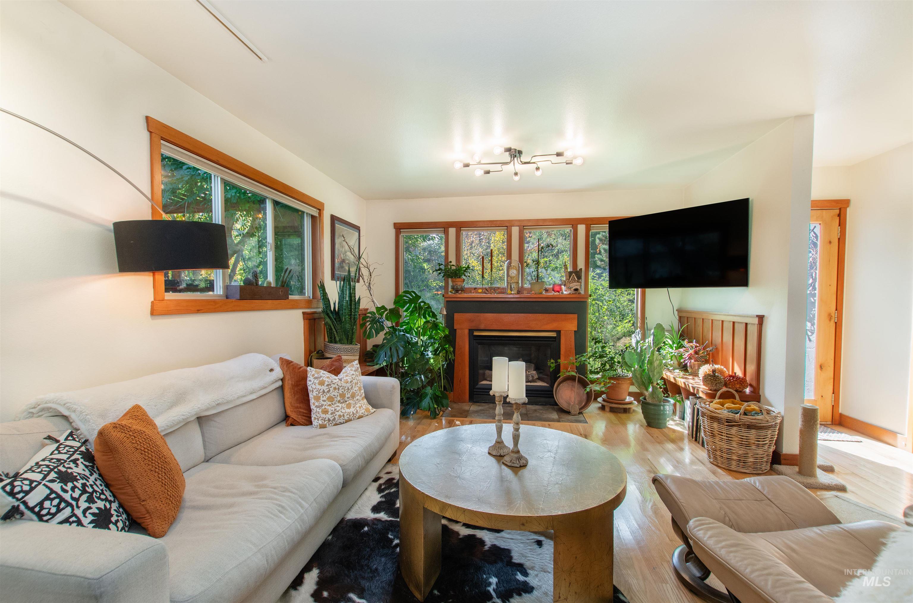 Living area featuring wood finished floors, a glass covered fireplace, and healthy amount of natural light