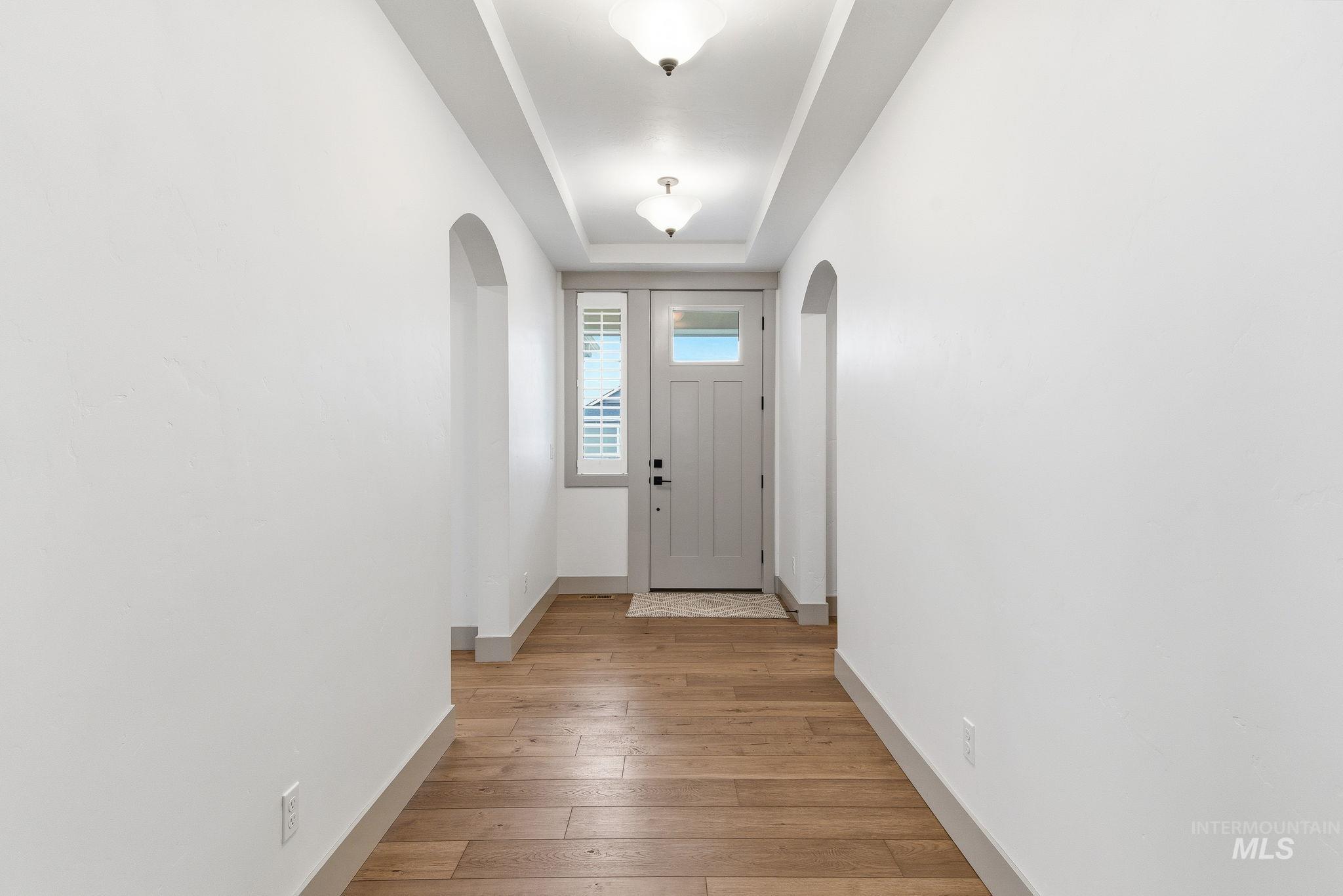 Entryway with wood-type flooring and a raised ceiling