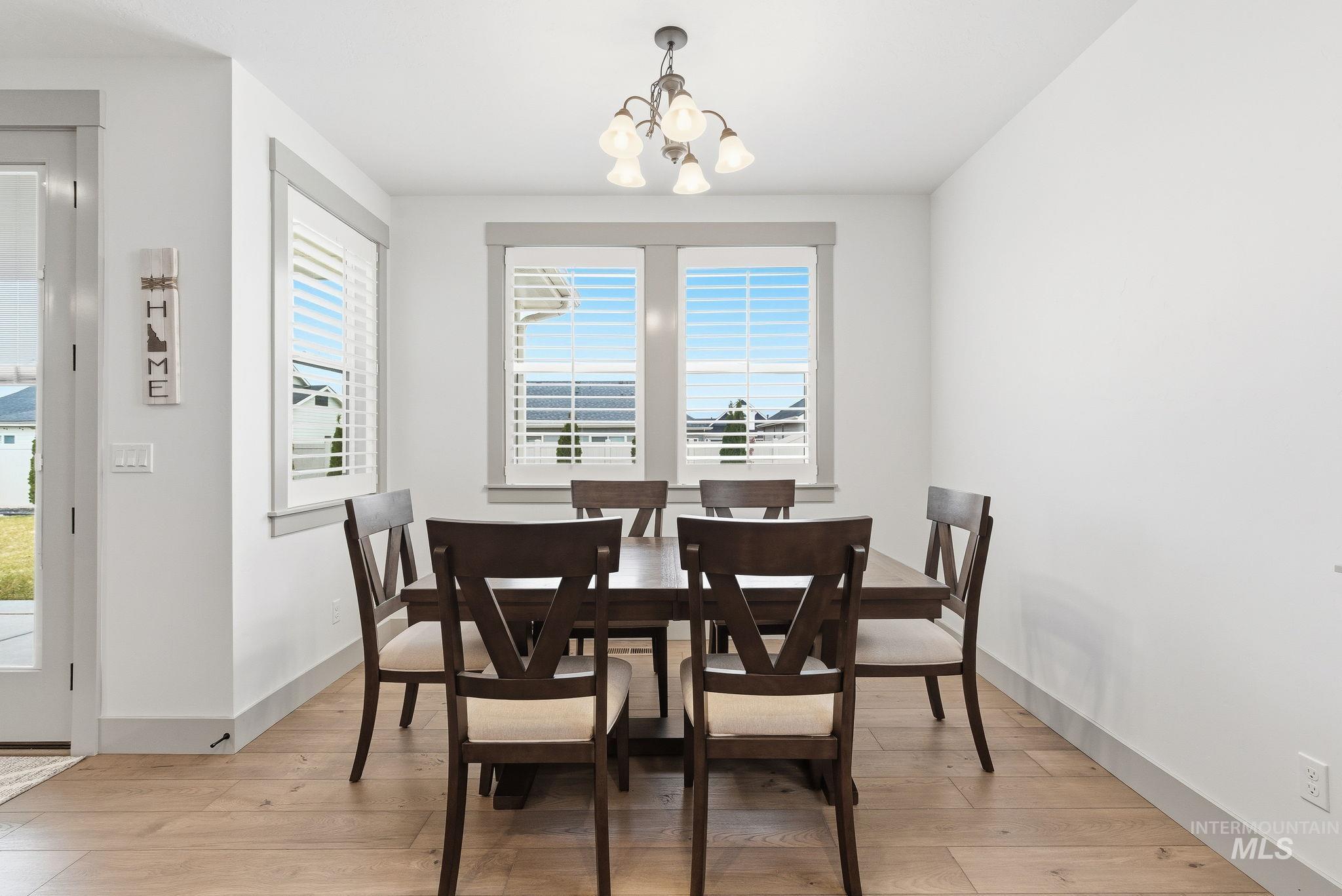 Dining space featuring plenty of natural light, a chandelier, and light wood-style floors
