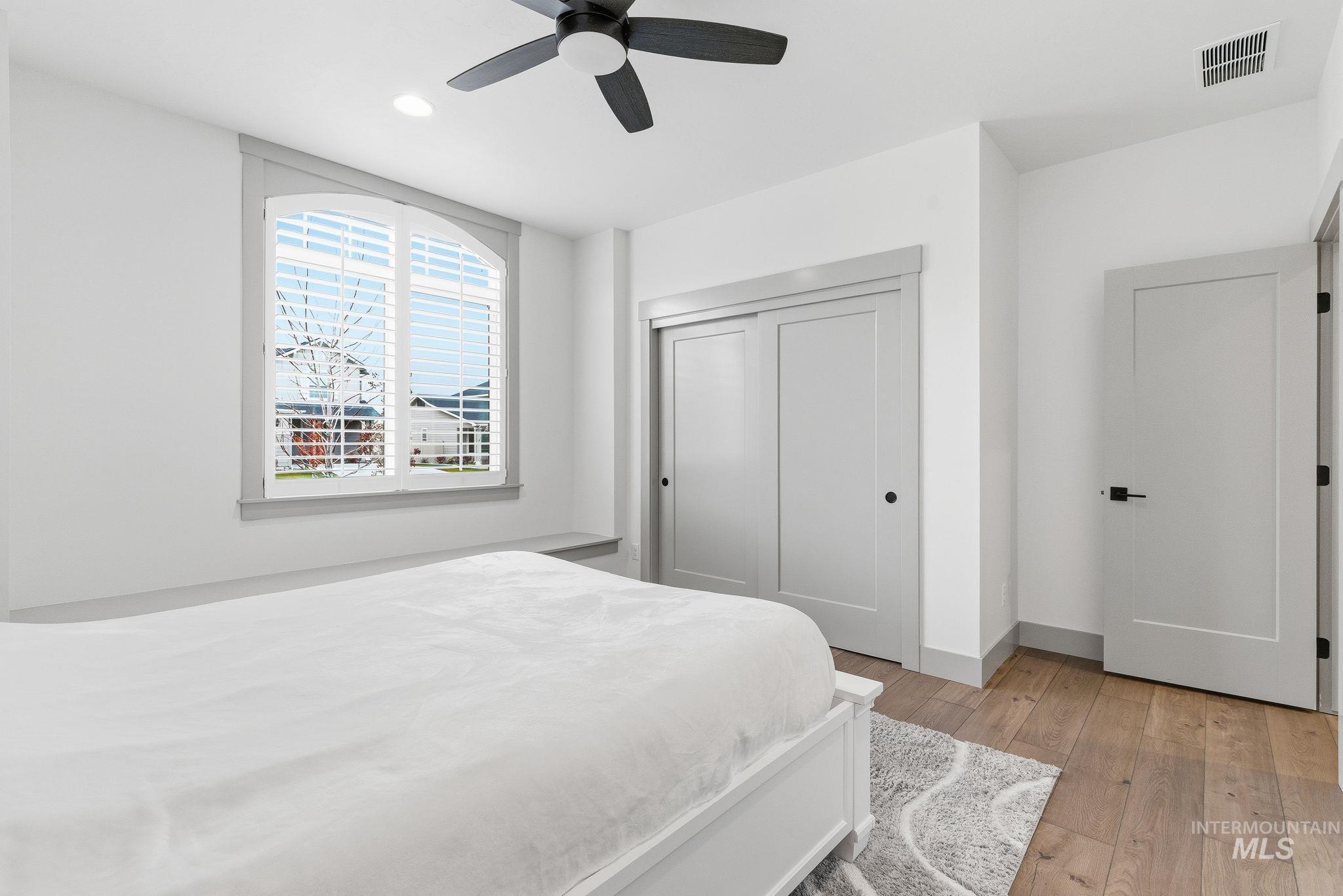Bedroom with light wood-style flooring, a closet, a ceiling fan, and recessed lighting