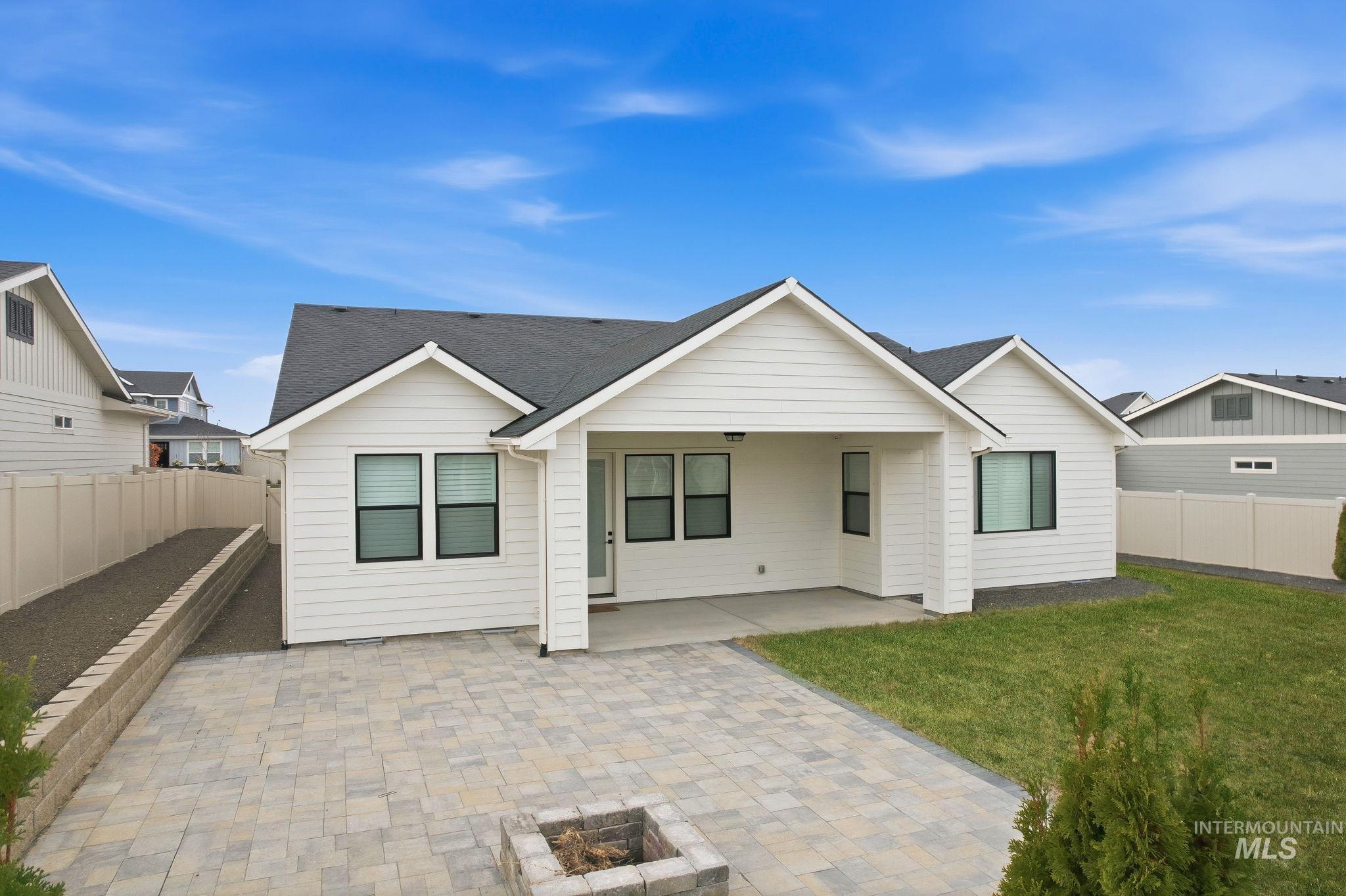 Rear view of property featuring a fenced backyard, a patio area, and roof with shingles