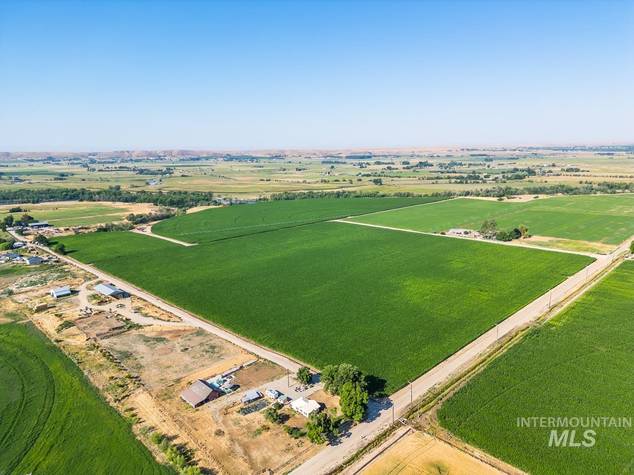 Aerial view of property and surrounding area featuring rural landscape and farmland