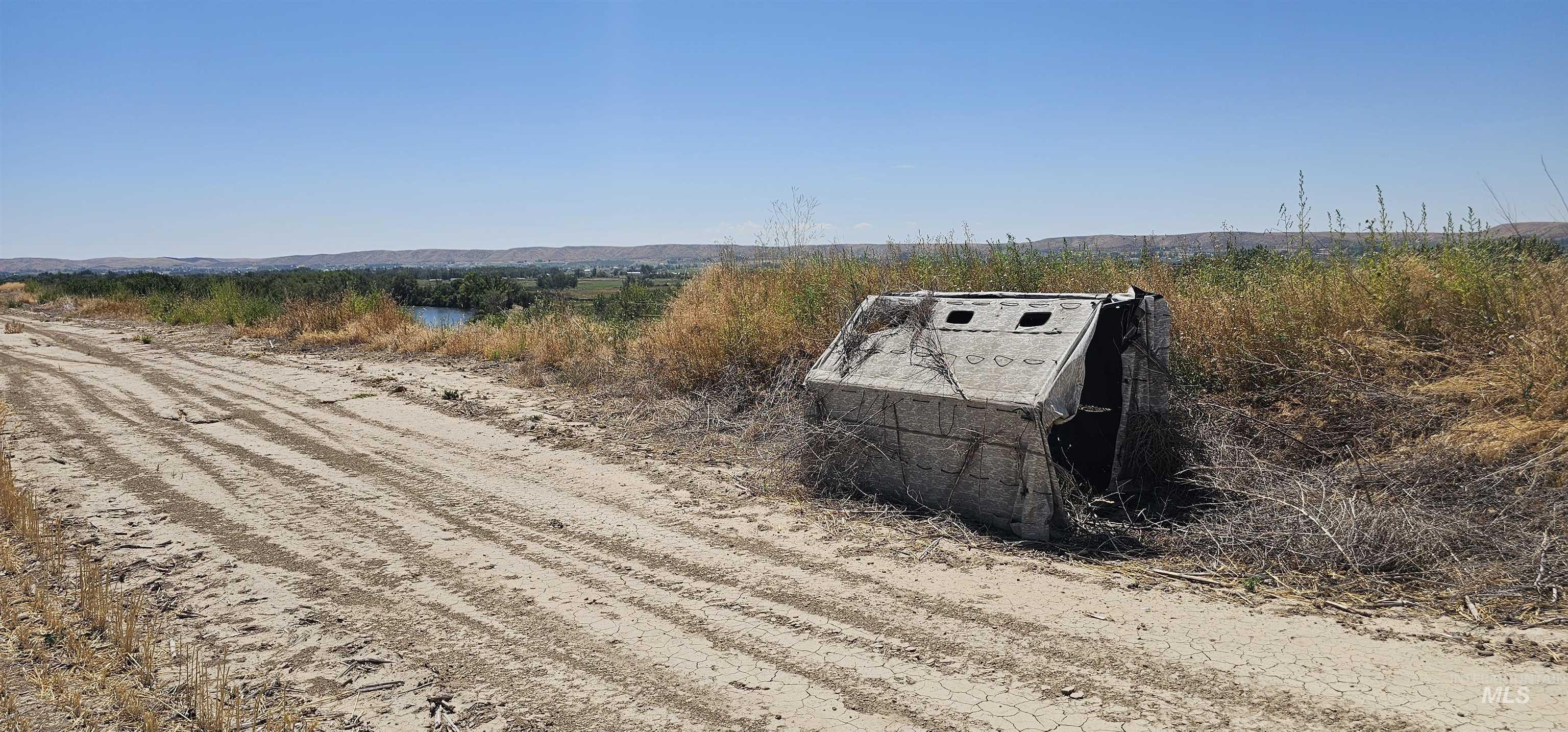 View of dirt / gravel road featuring a view of rural / pastoral area