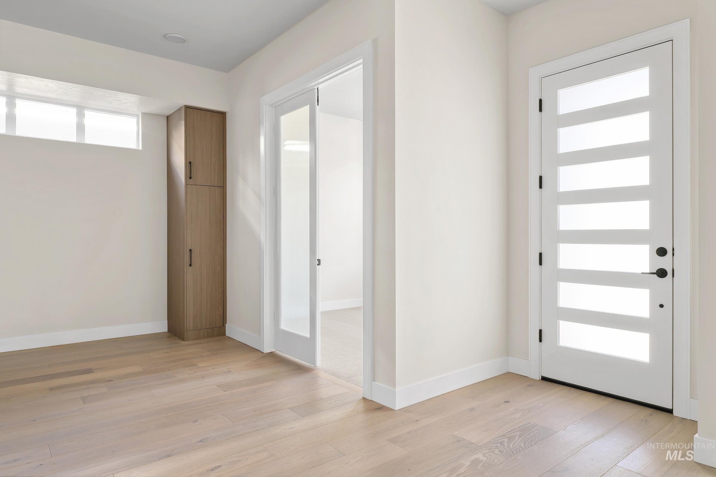 Entrance foyer with light wood-style floors and baseboards