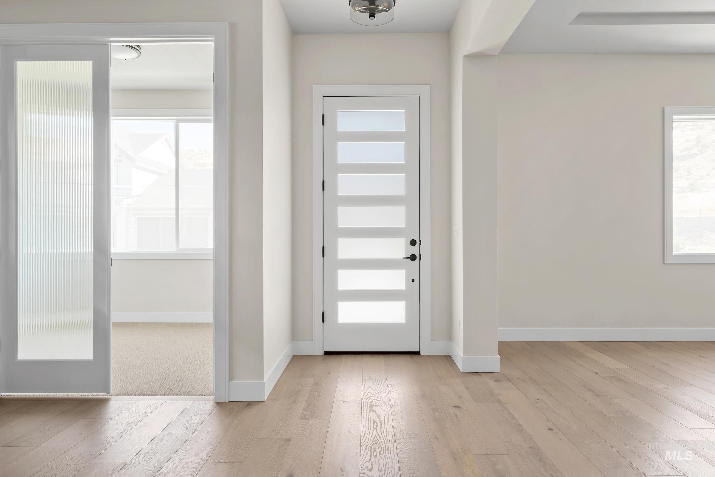 Entrance foyer with light wood-style floors and baseboards