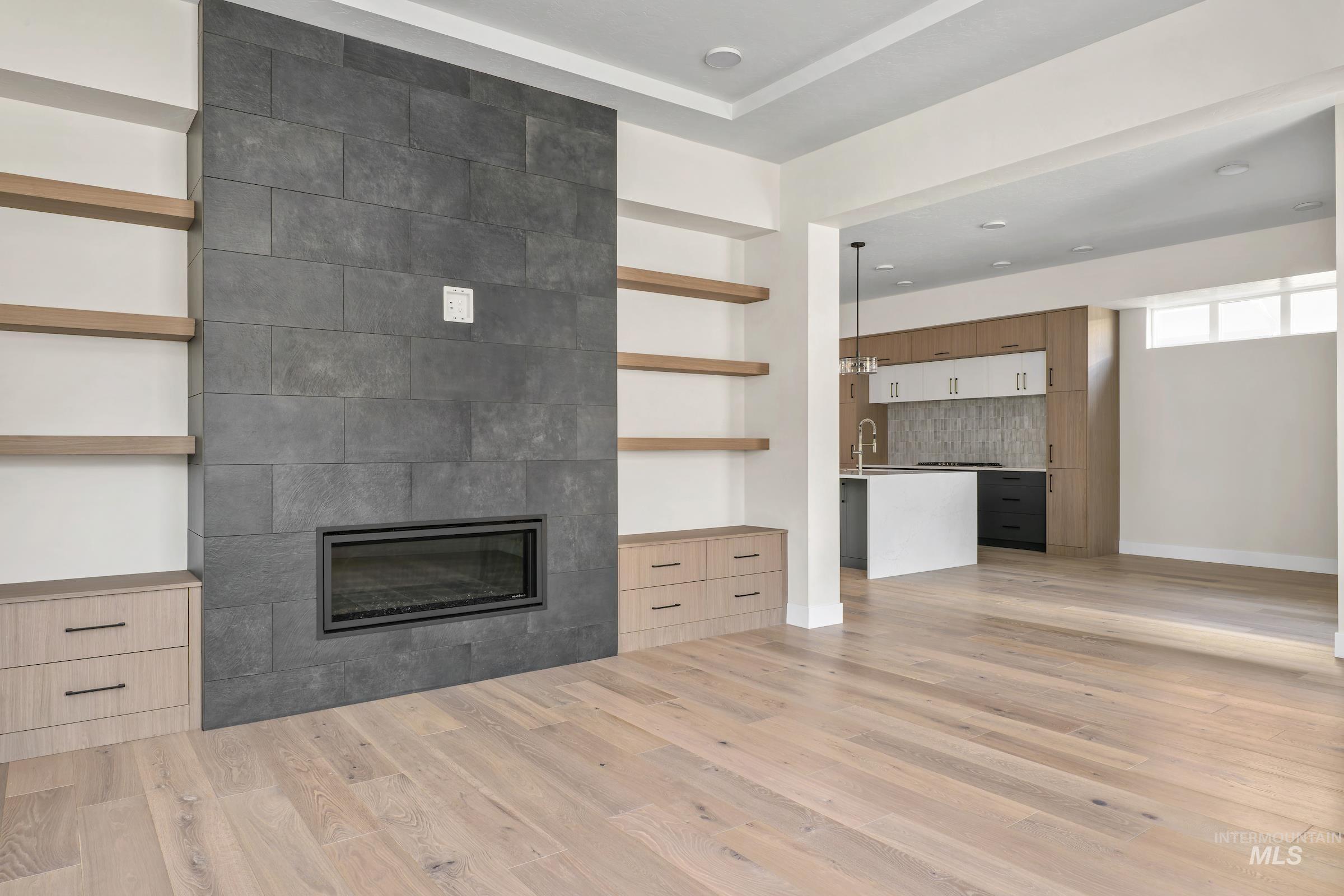 Unfurnished living room featuring a large fireplace and light wood-style flooring