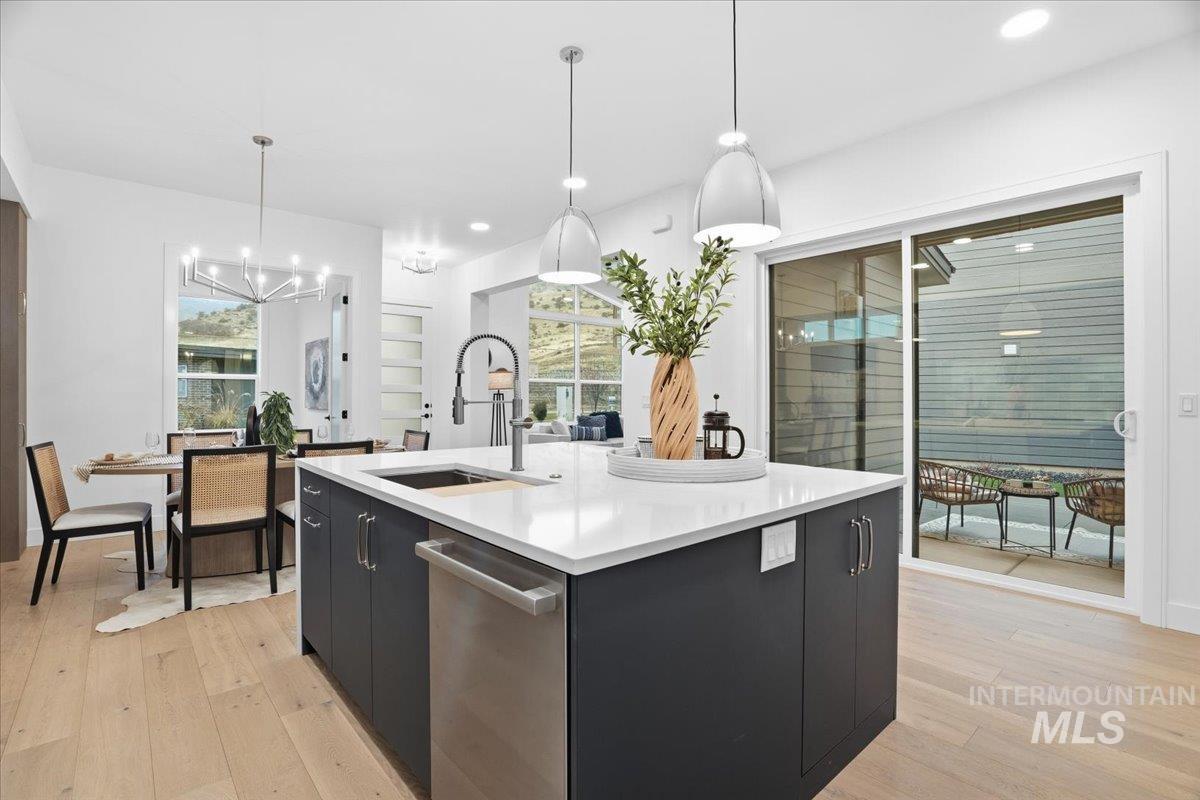 Kitchen with dark cabinetry, decorative light fixtures, a kitchen island with sink, modern cabinets, and recessed lighting